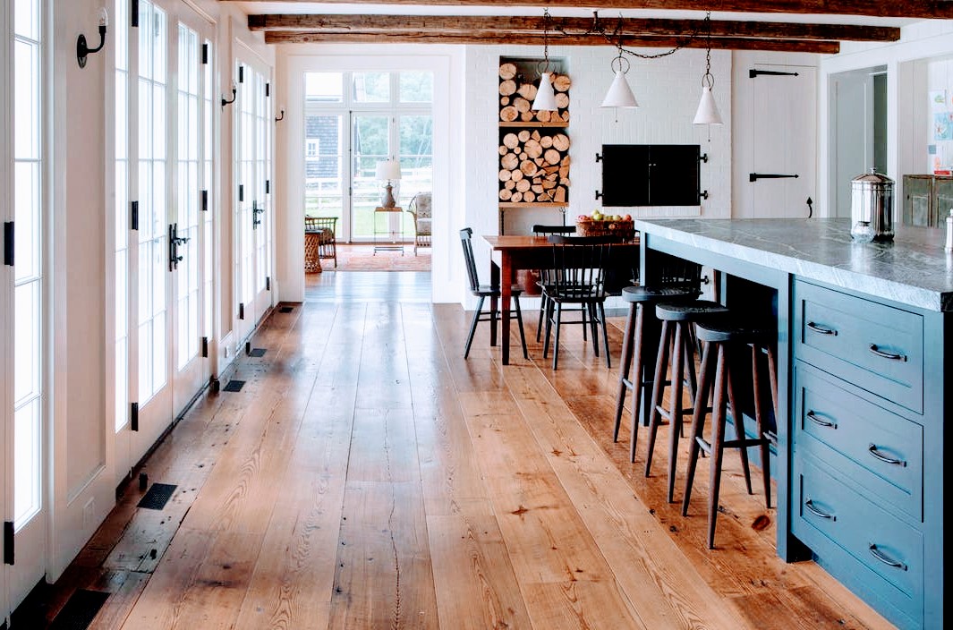Modern kitchen and dining area with hardwood floors and white cabinetry