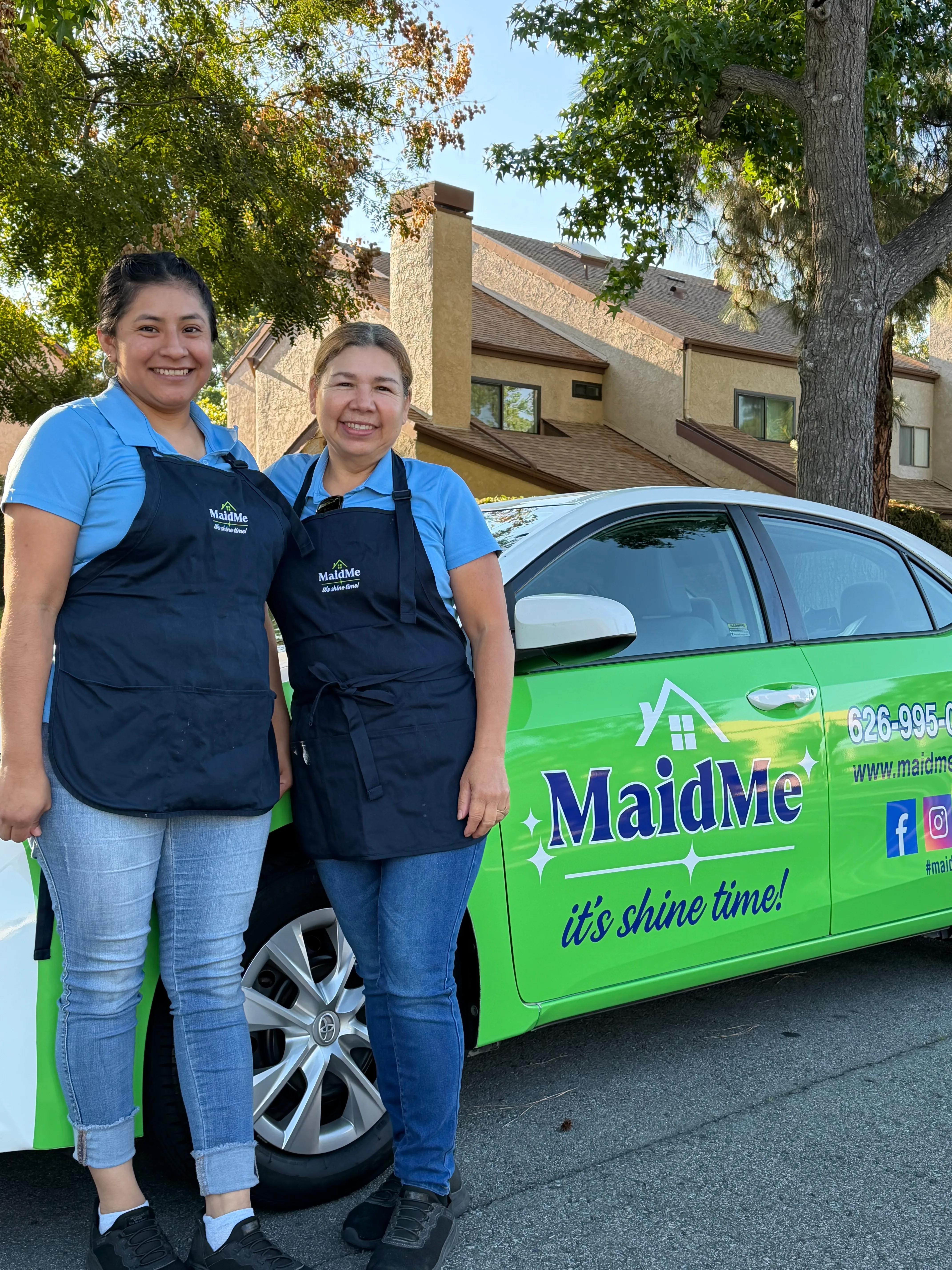 MaidMe team members in branded uniforms standing next to their service vehicle