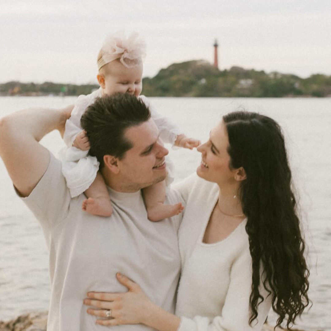Daniel, Owner of Dryer Vent Doctors, with his wife and baby enjoying a scenic waterfront