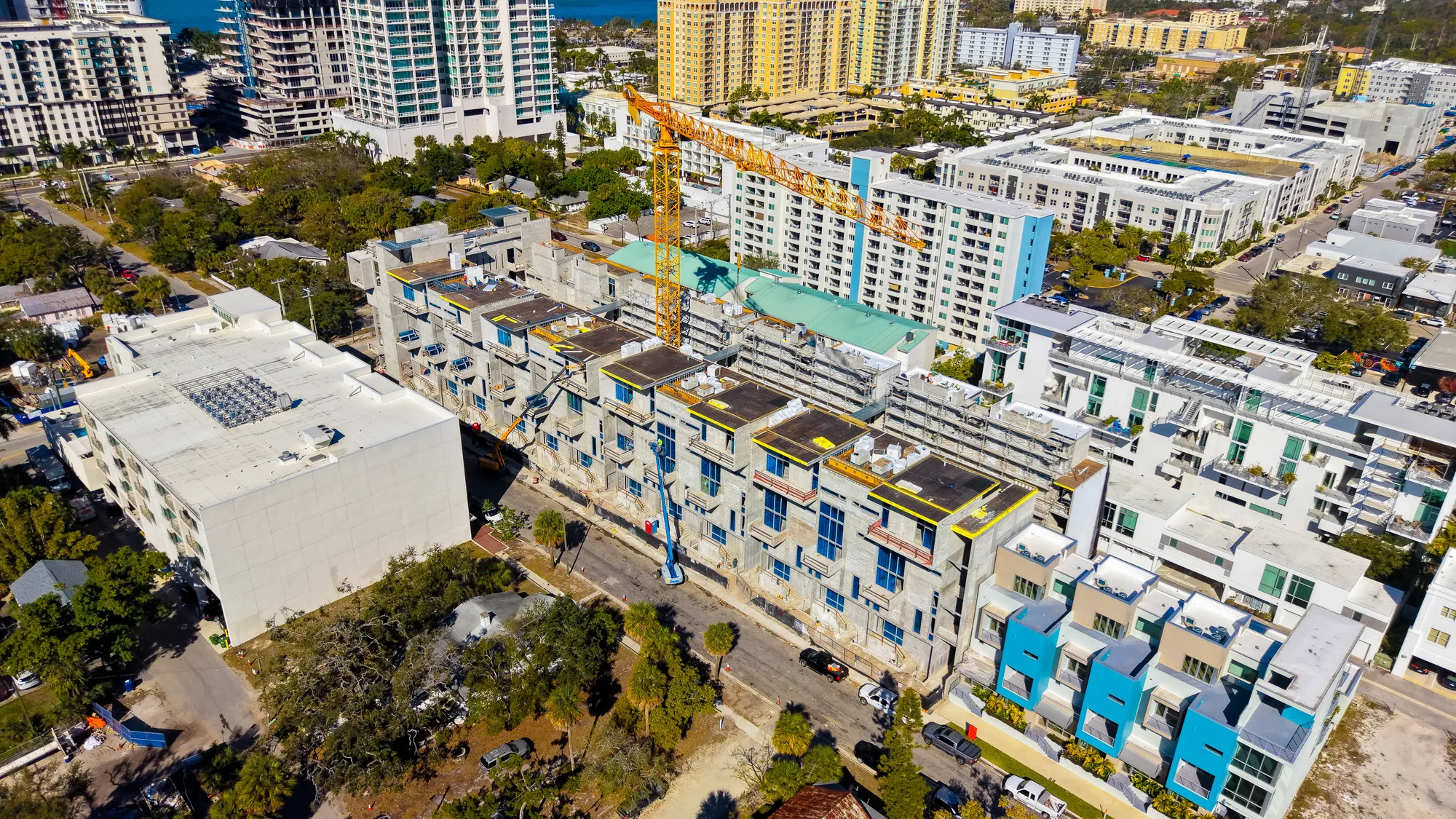 Aerial of The Epoch, a glass-and-white residential tower, against a clear blue sky.