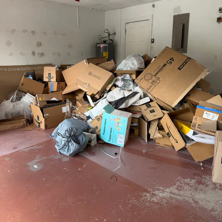 Garage filled with boxes, bags, and packing debris before a Dump Wizard cleanout