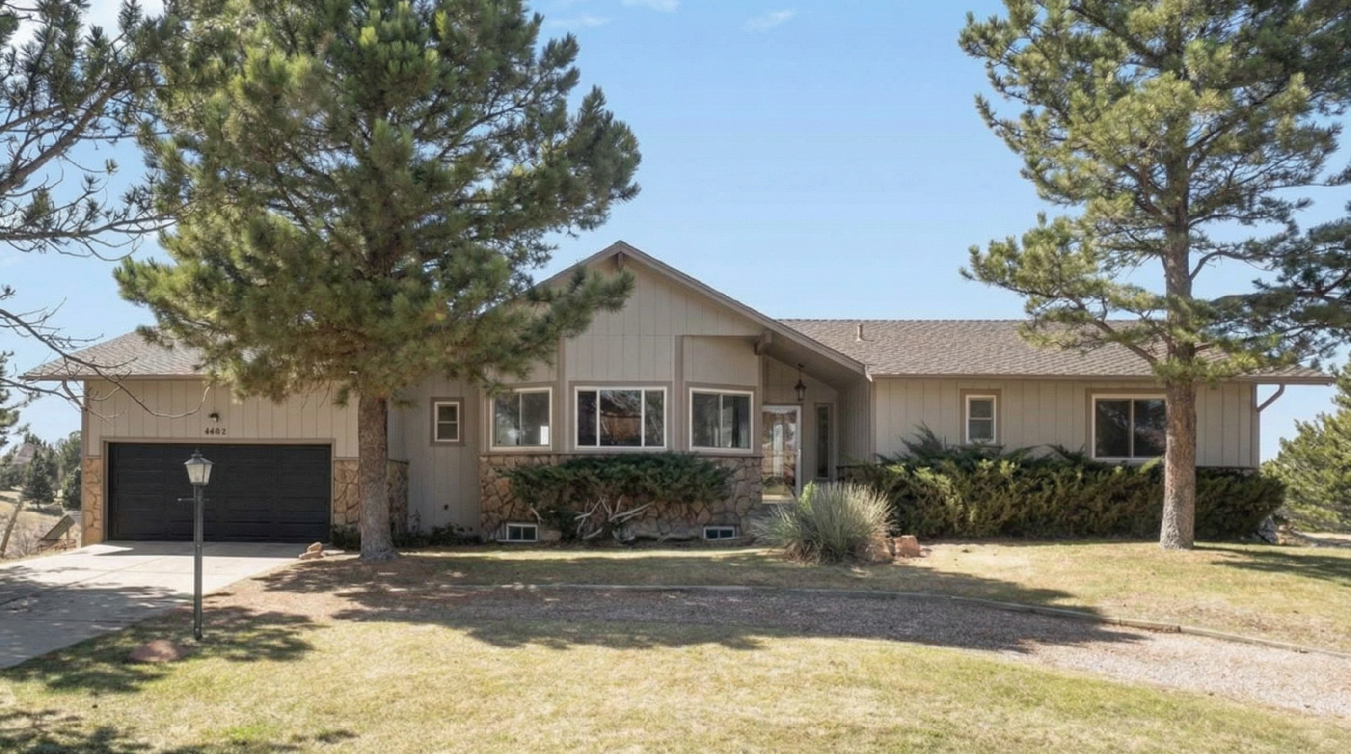 Single-story home with beige siding and stone accent