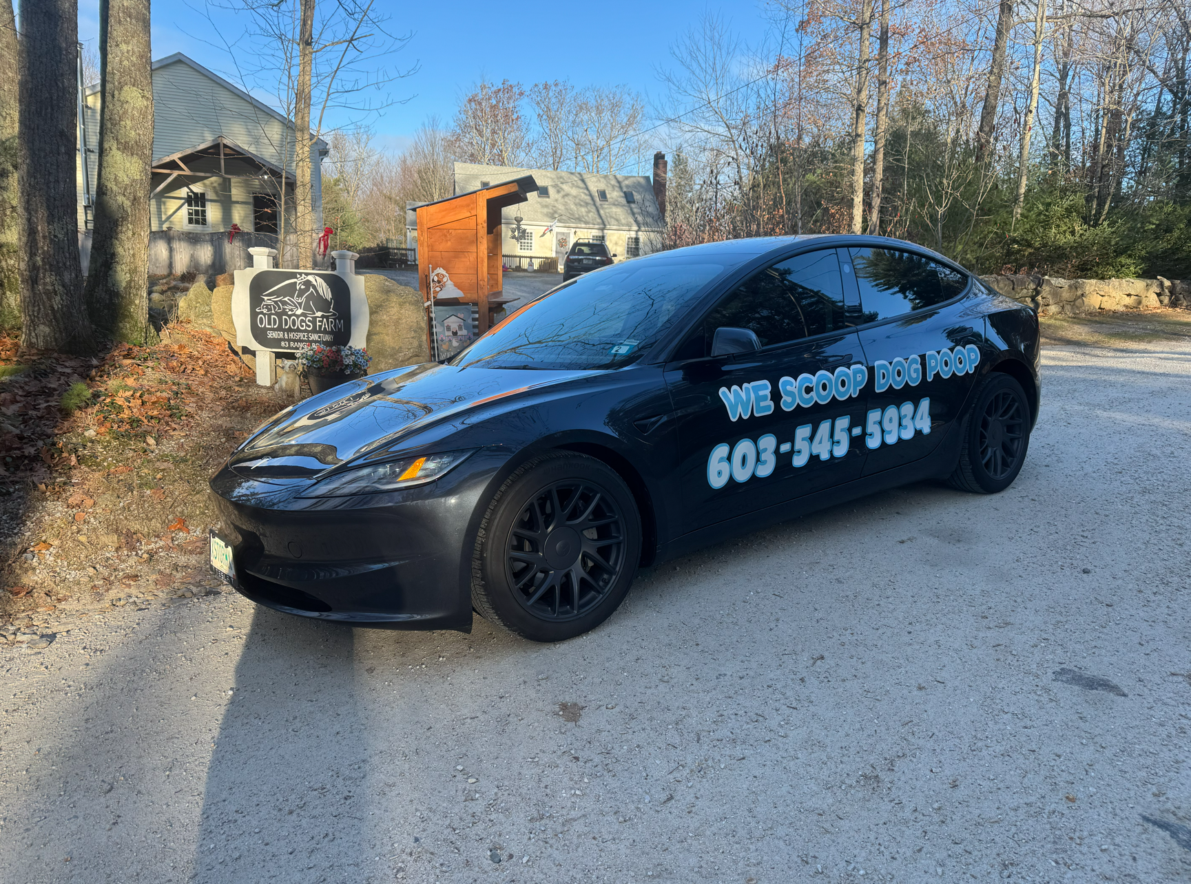 Savy Poop Pickup car parked beside the Old Dogs Farm sanctuary sign among autumn leaves