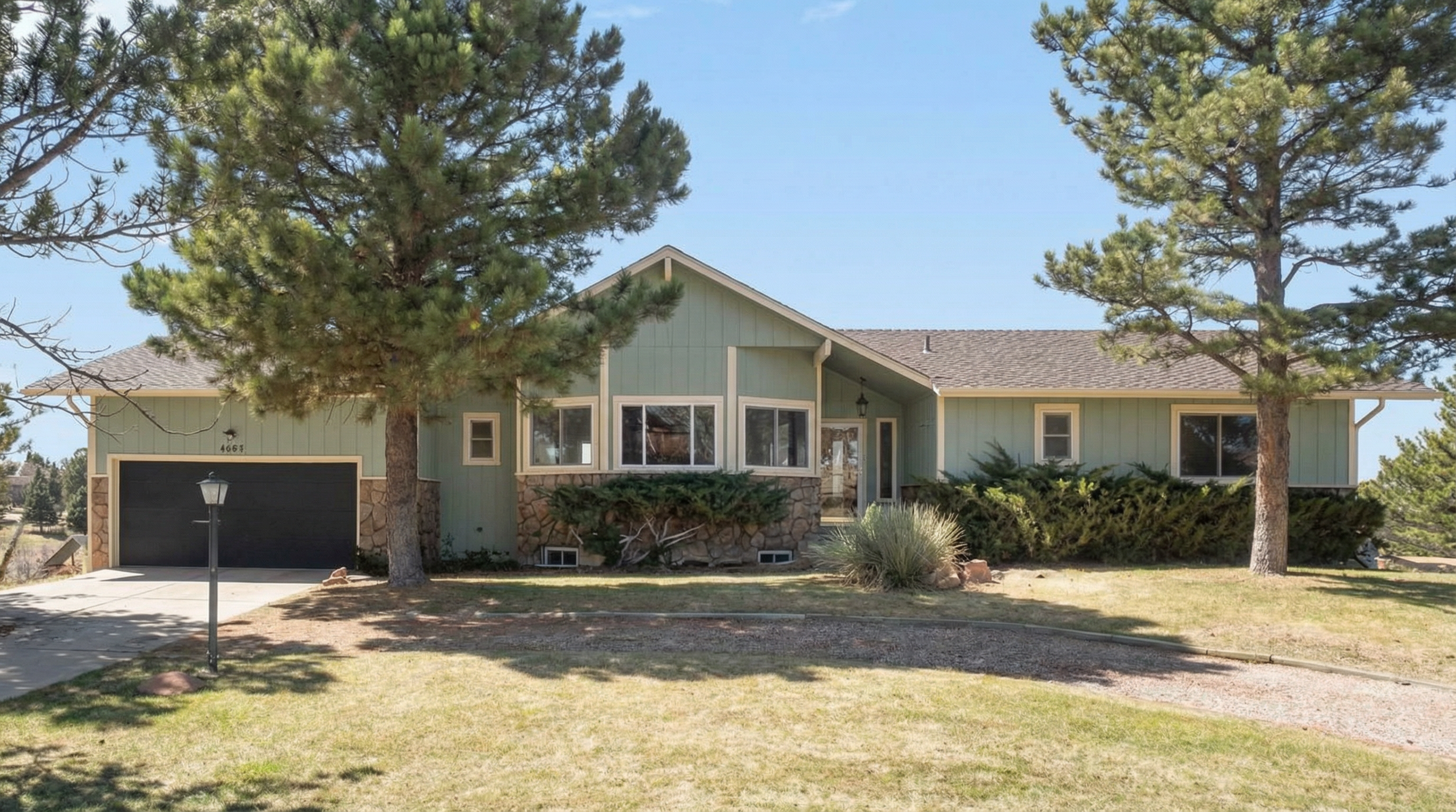 Modern single-story home with green exterior and stone front