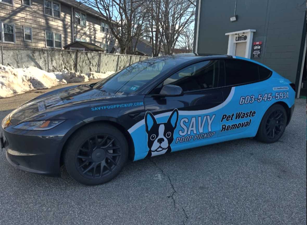 Savy Poop Pickup car parked in front of a building with snow and fencing behind it