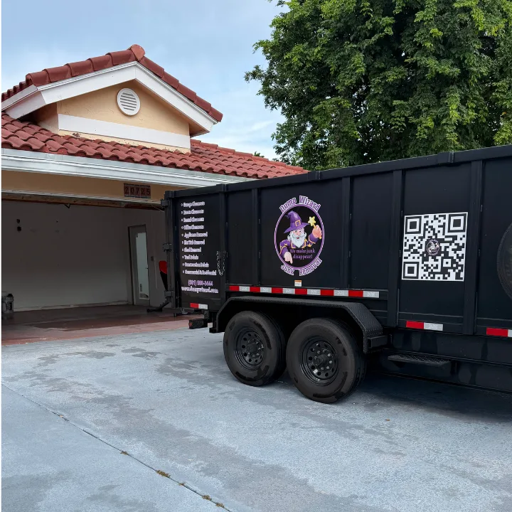 Dump Wizard trailer backed up the driveway to an open garage, ready to load