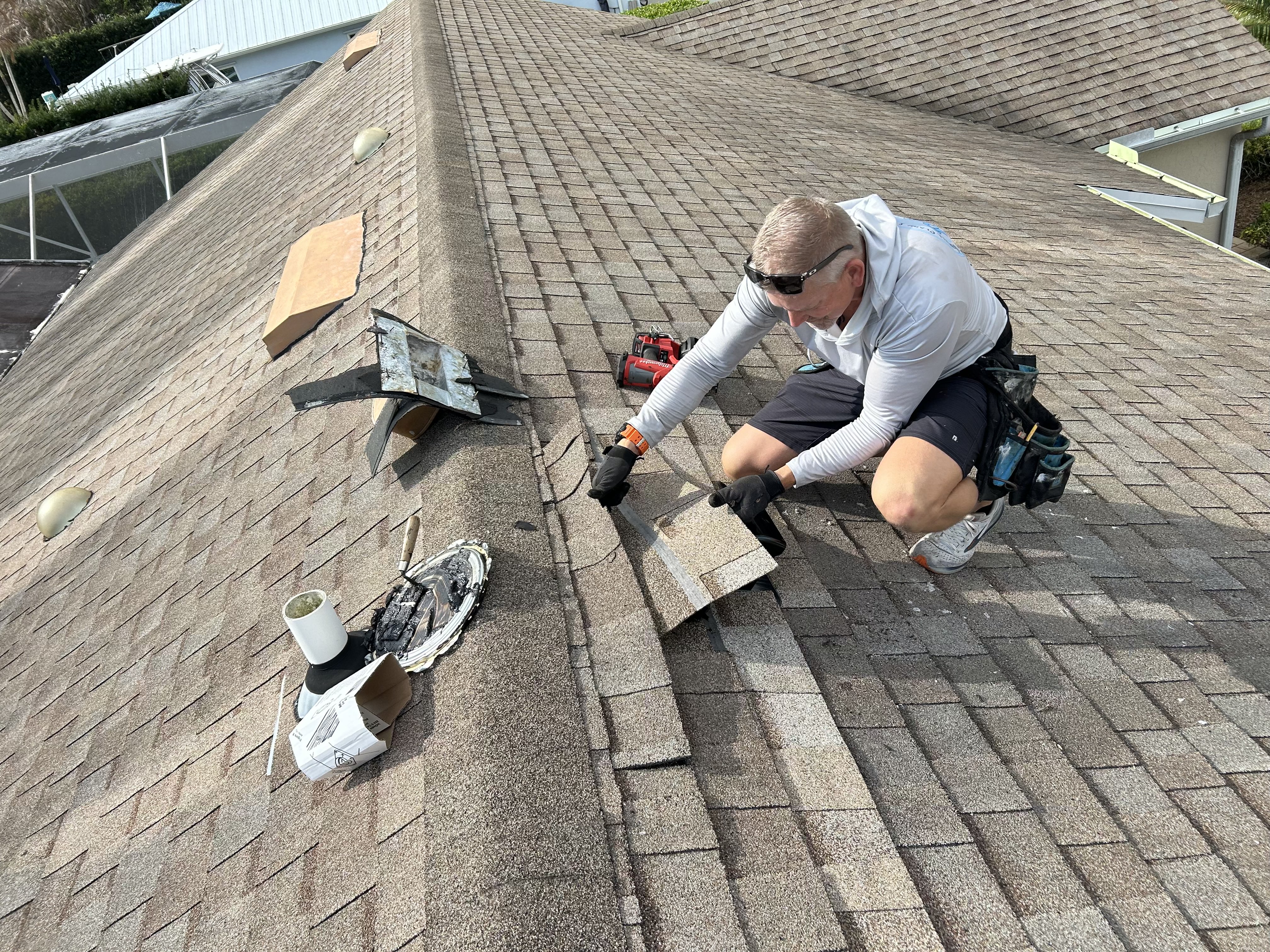Roofer installing new shingles on a Treasure Coast home