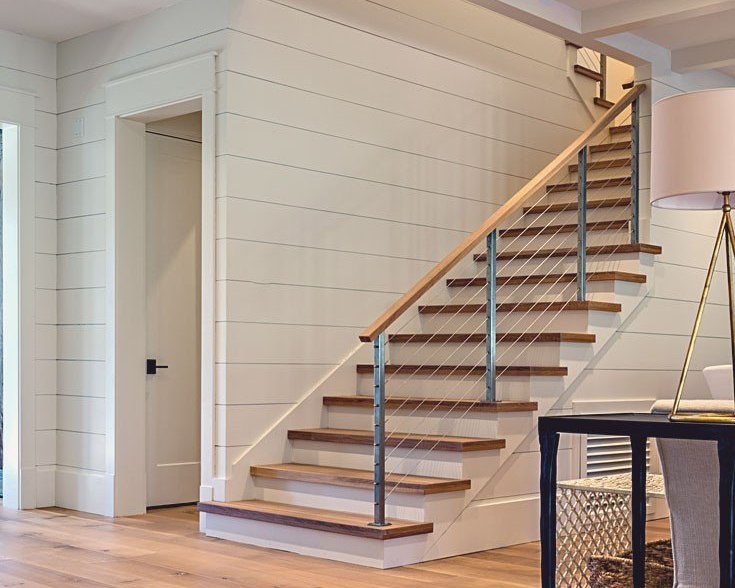 Modern staircase with hardwood steps and metal railing