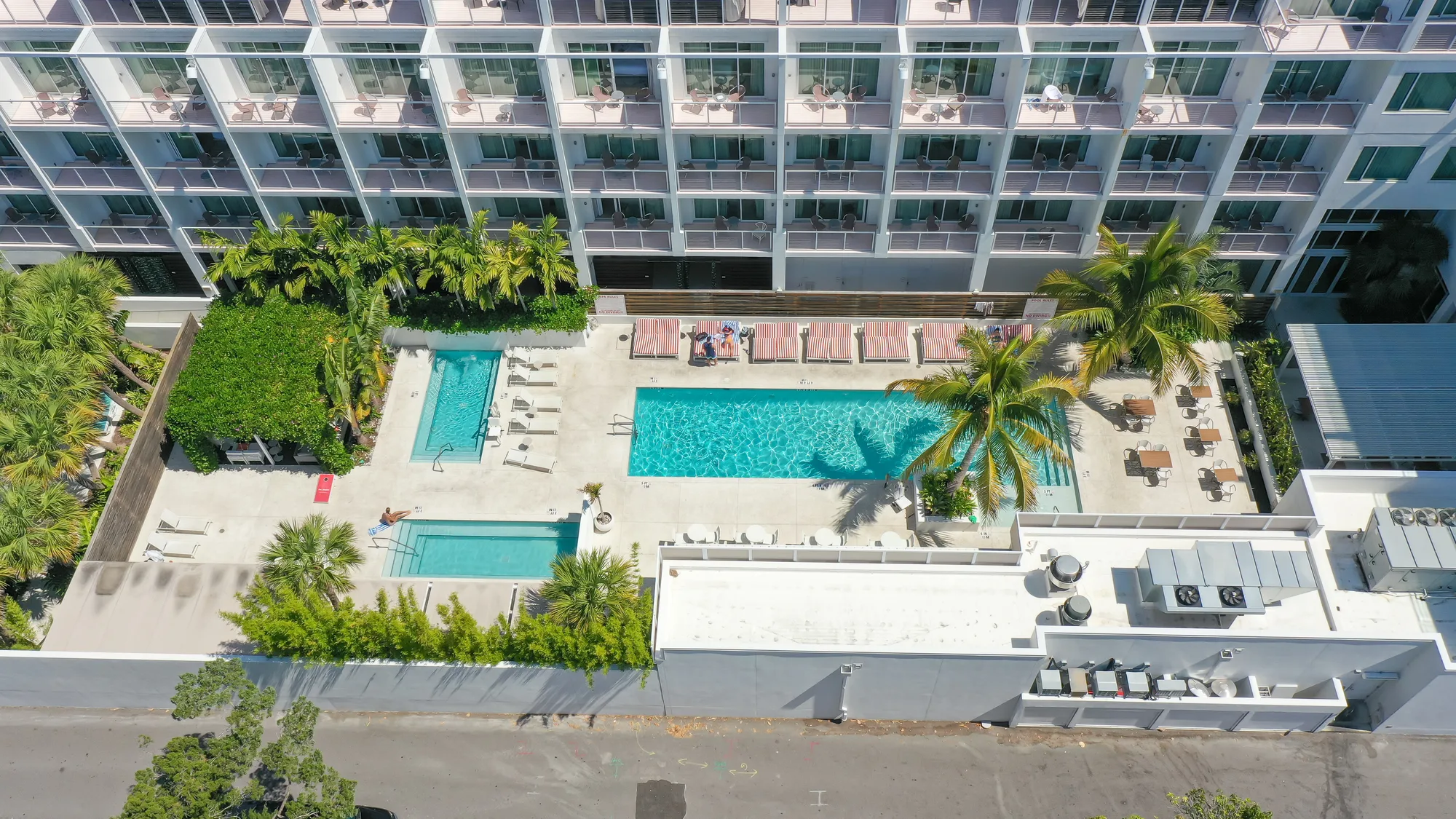 Aerial of the pool courtyard at The Sarasota Modern Hotel, with loungers and palms around the water.