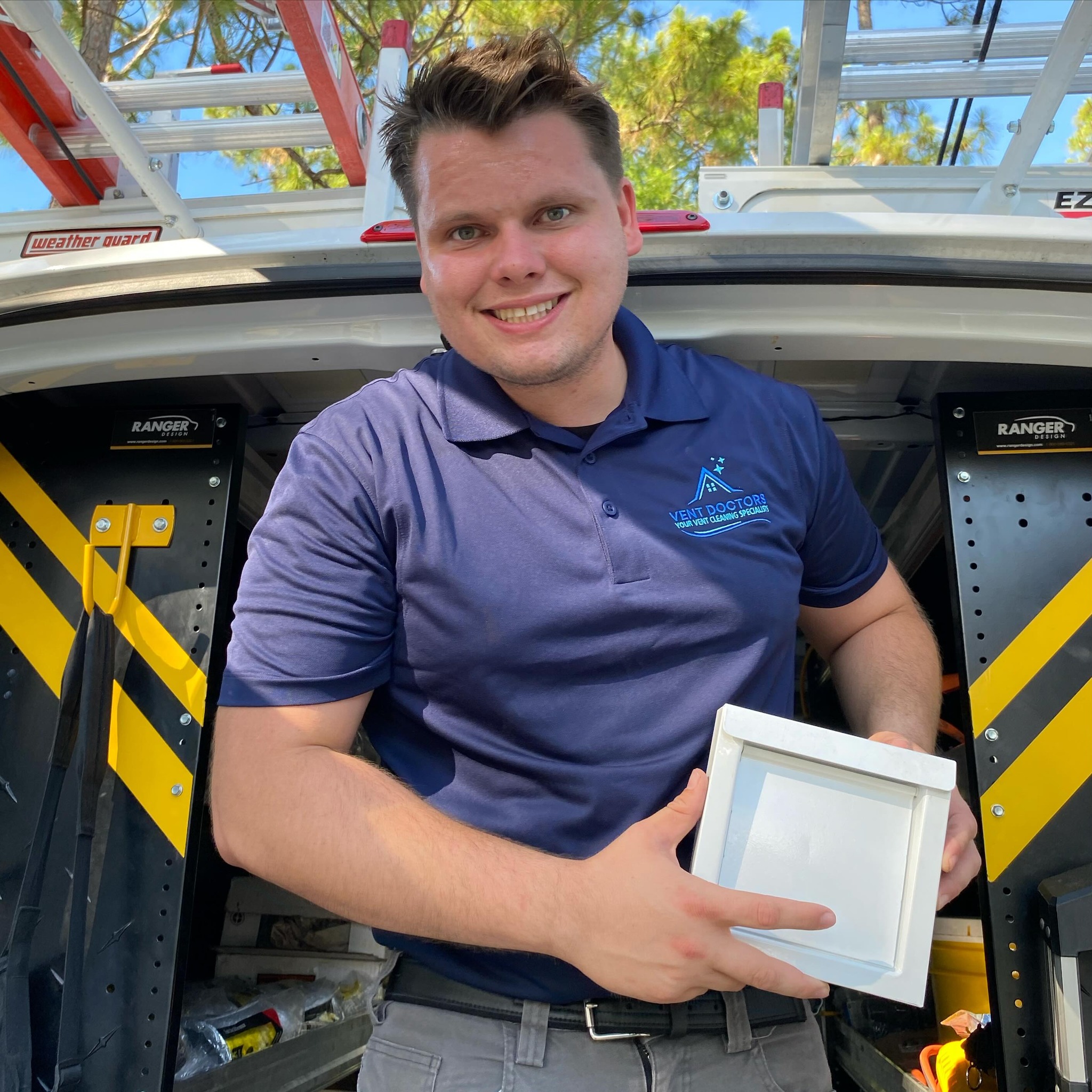 Dryer Vent Doctors technician standing beside service van with professional cleaning equipment
