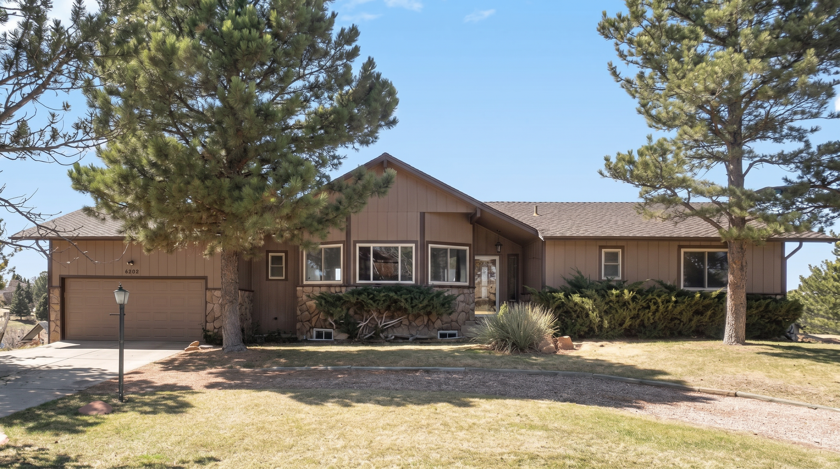 Contemporary ranch-style home with brown exterior and stone accents