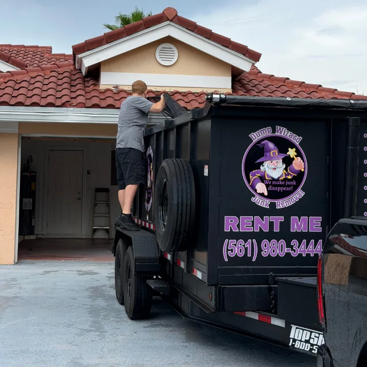 Chase tarping a fully loaded Dump Wizard trailer at the end of a job