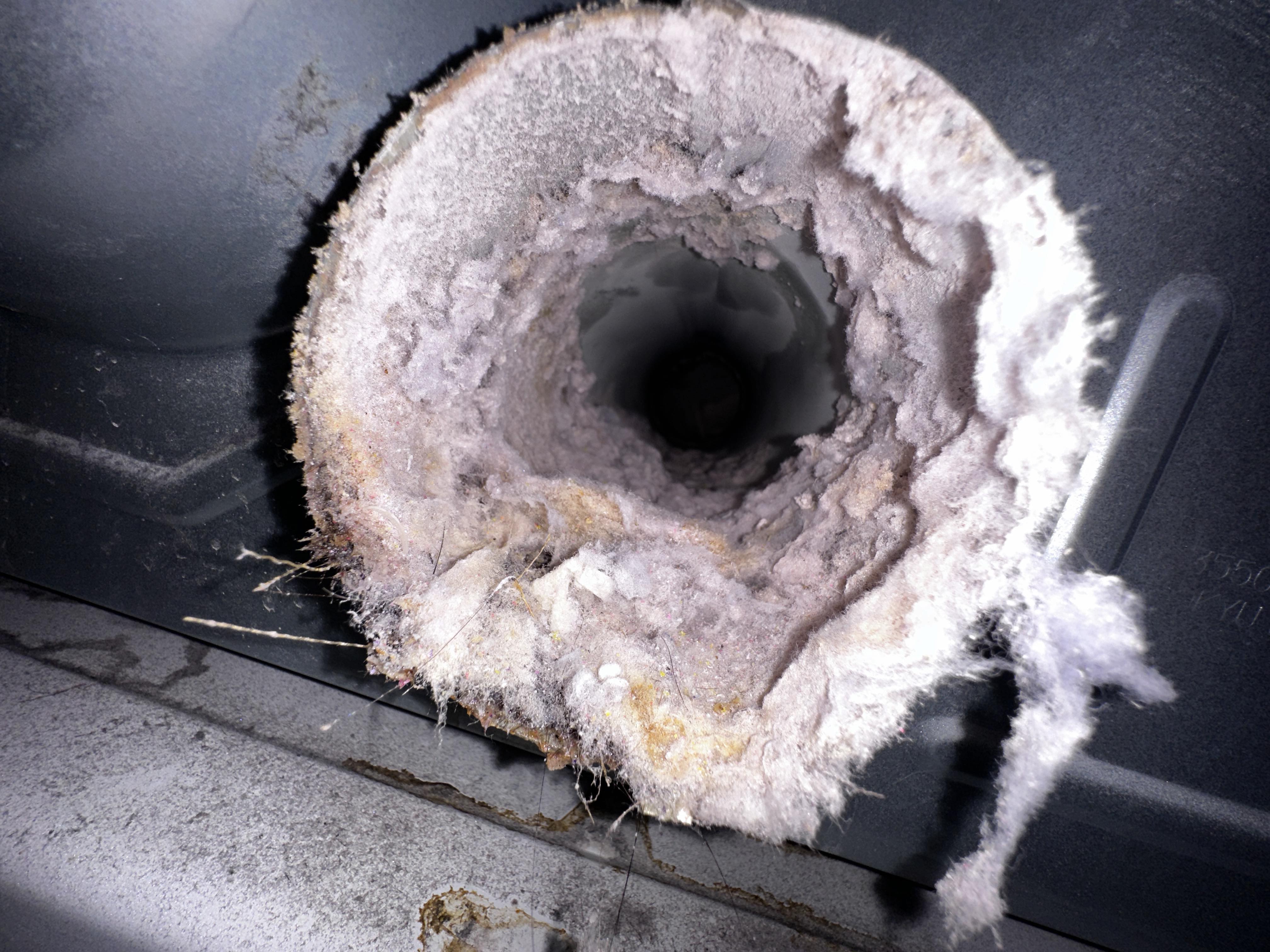 Interior view of a dryer vent heavily clogged with lint and debris