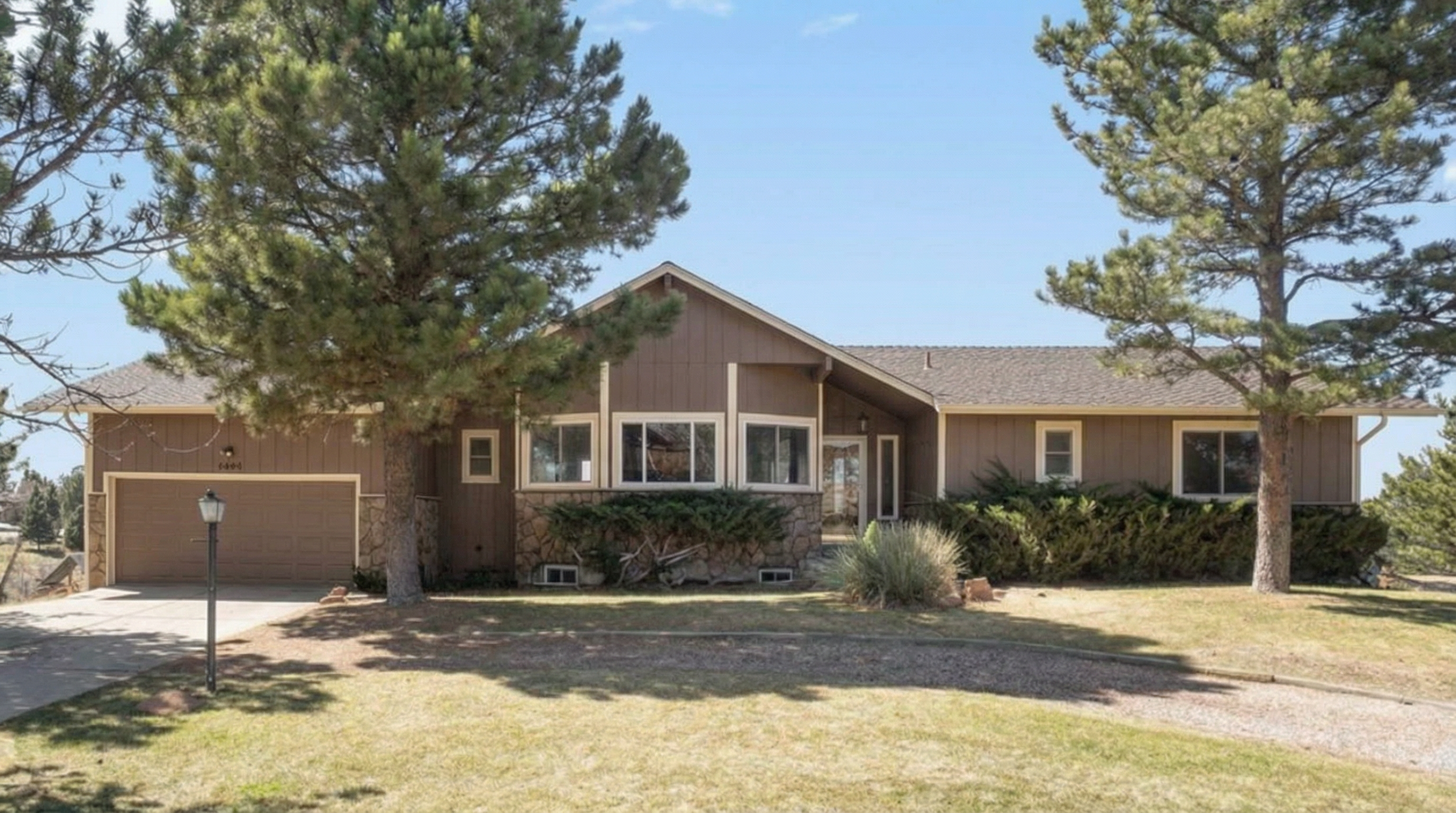 Single-story house with brown exterior and stone-accented facade