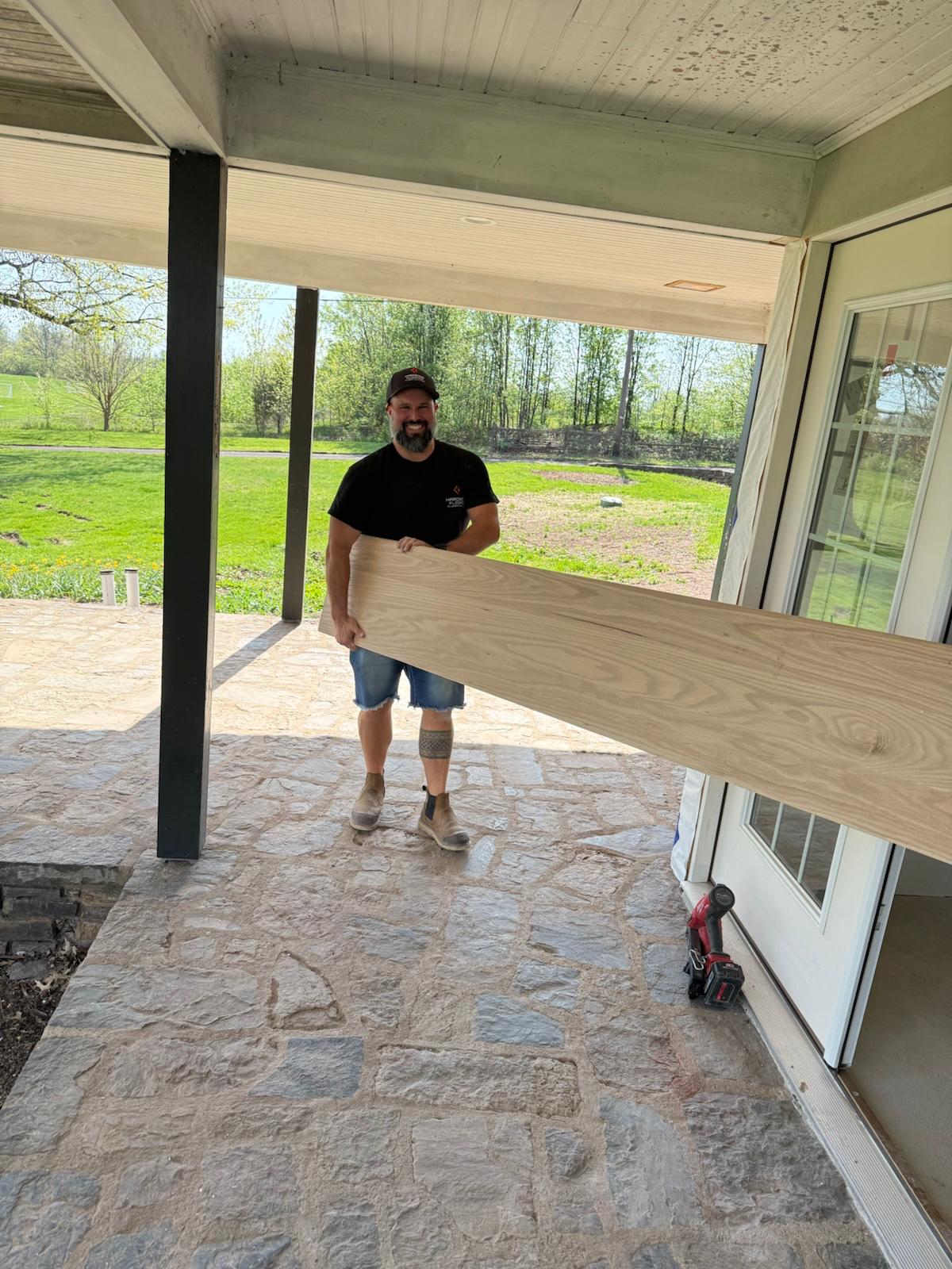Christopher Gross carrying lumber at a residential job site, ready to get to work