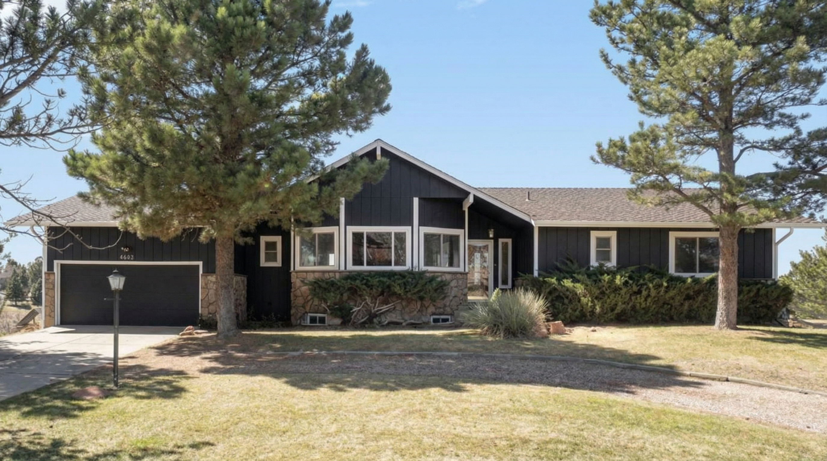Modern house with dark siding and stone foundation