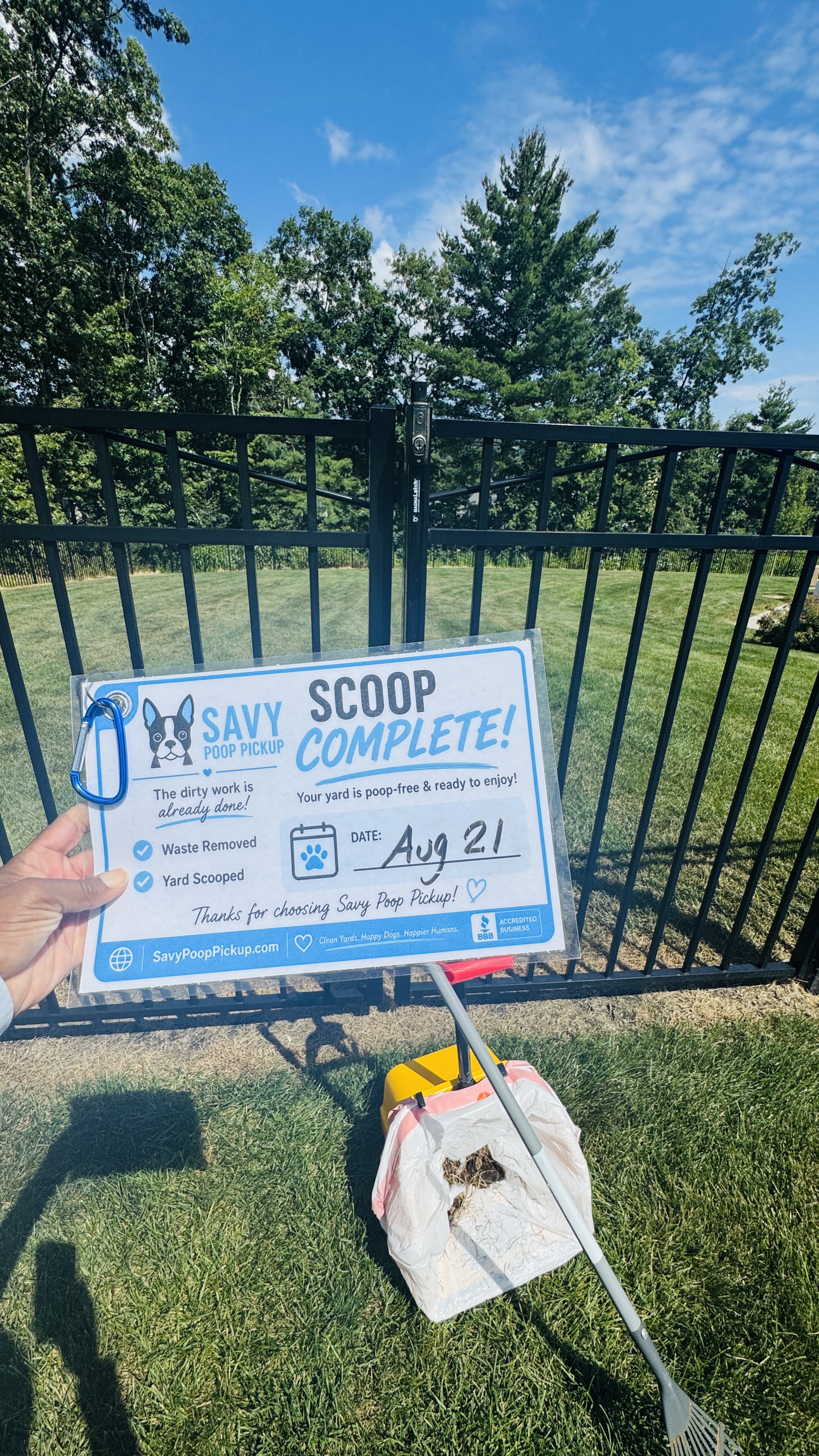 Scoop Complete card left in a customer yard next to a waste collection bag and rake