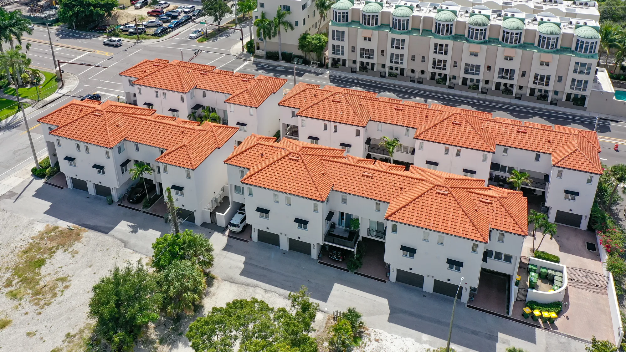 Close aerial of The Encore, a row of townhomes with terracotta tile roofs and two-car garages.