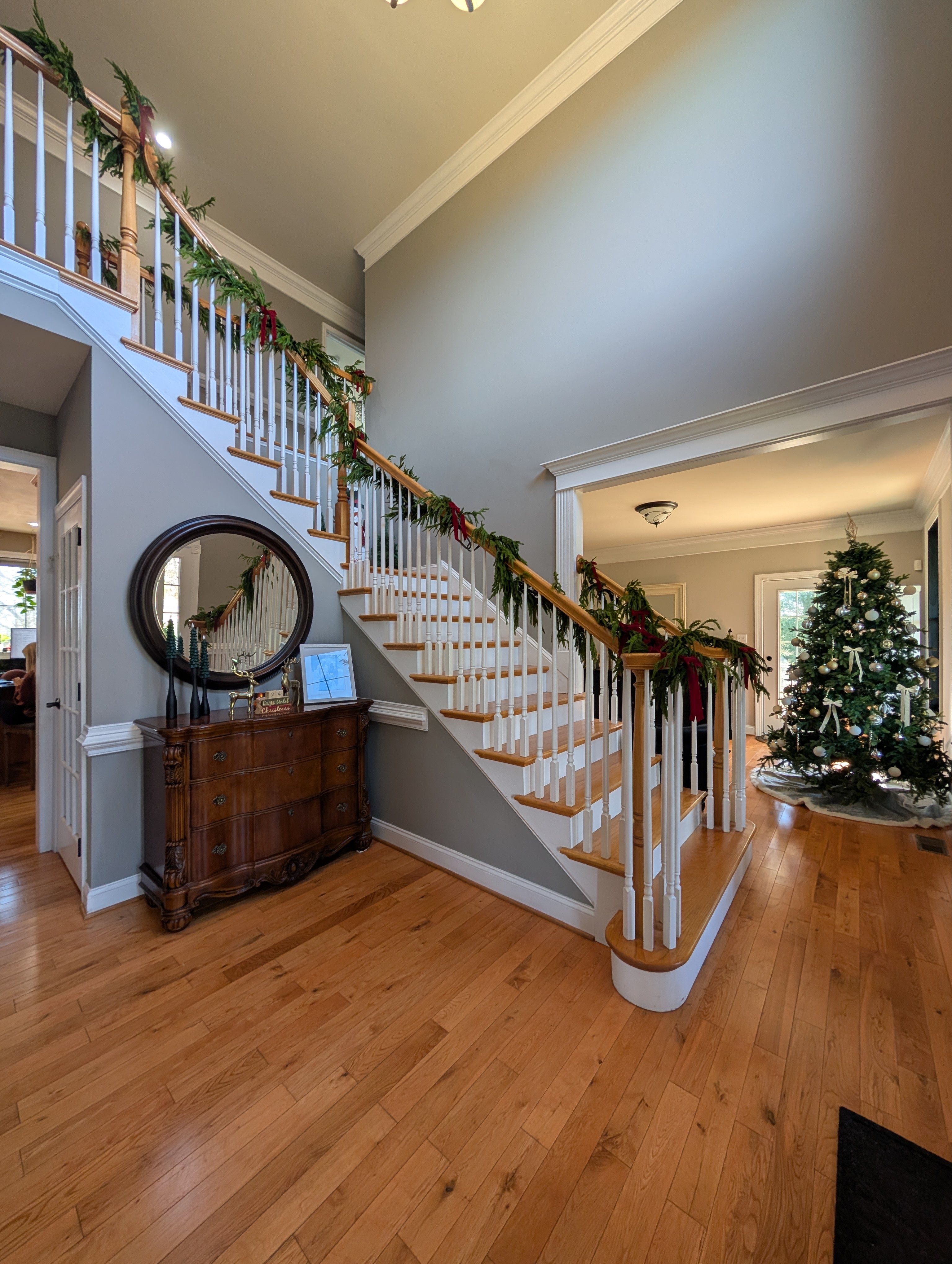 Traditional staircase with turned balusters and hardwood treads in a classic entryway