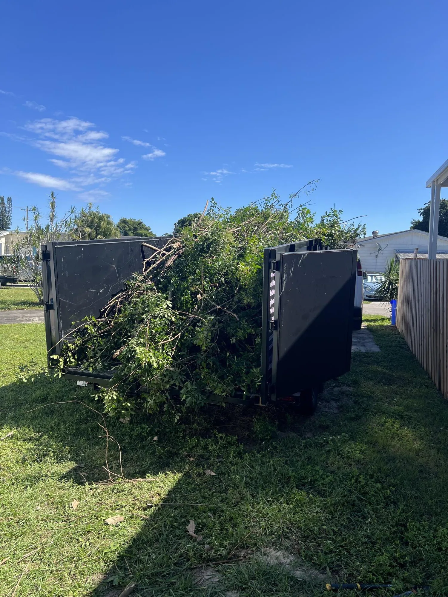 Dump Wizard trailer loaded with branches and yard waste