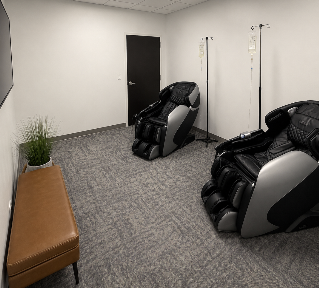 The IV therapy lounge at Forge Health & Performance, with comfortable massage recliners and IV stands in a quiet, minimal room.
