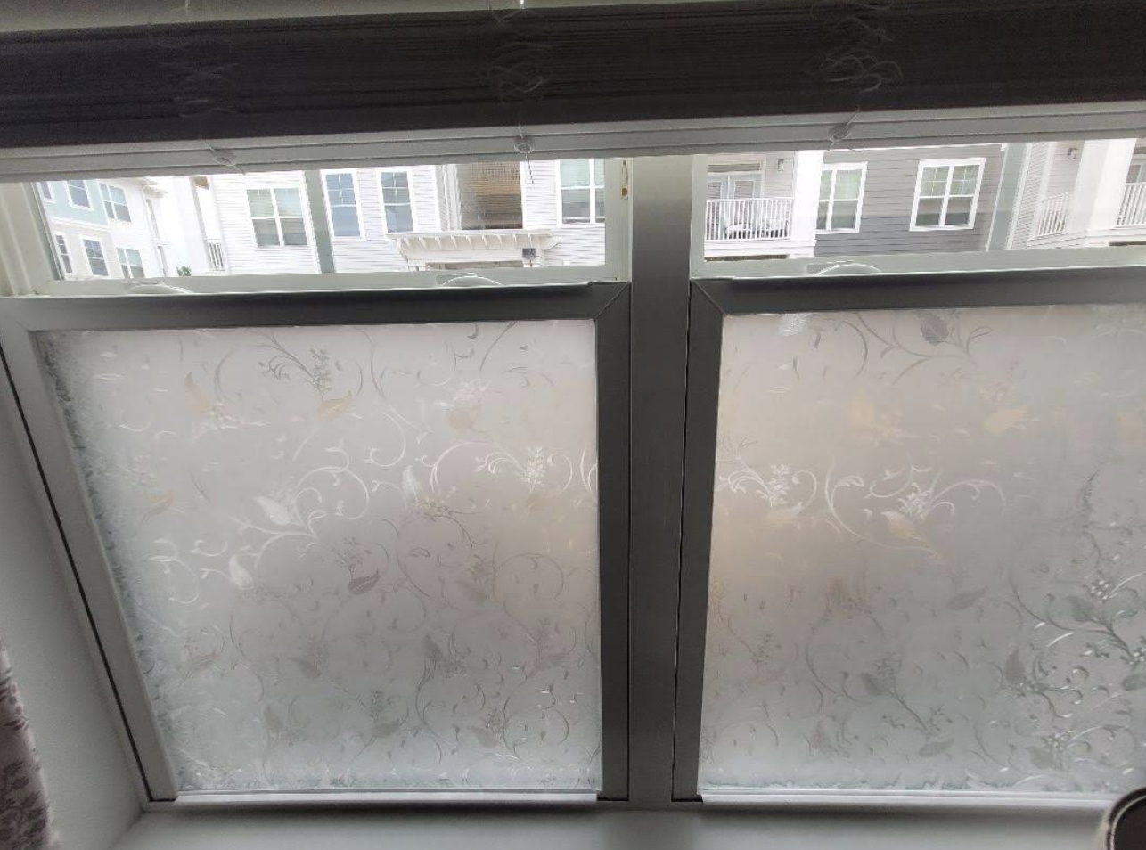 Window with frosted floral-pattern glass and wood trim ready for finish work