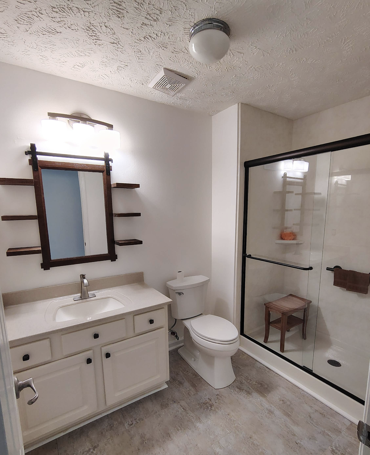 Clean modern bathroom with a white vanity, glass shower enclosure, and fresh fixtures after installation