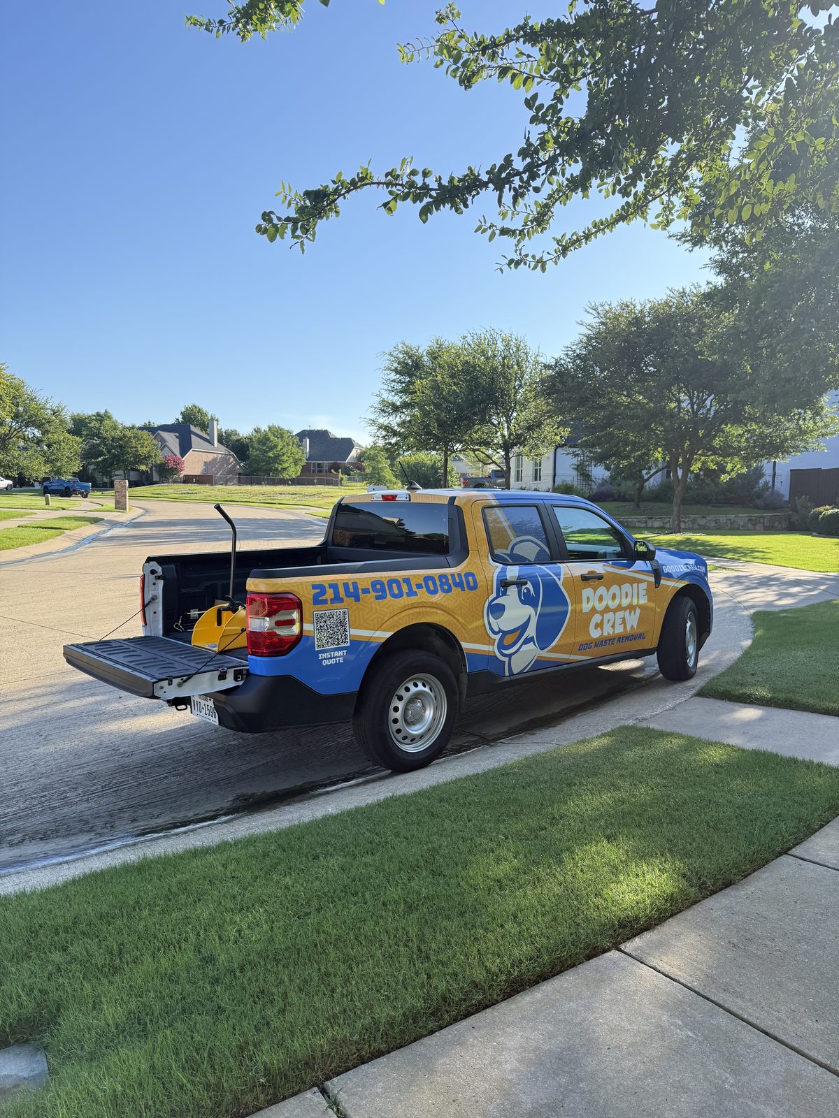 Doodie Crew branded pickup truck with playful dog logo parked in a suburban neighborhood serving Celina, TX