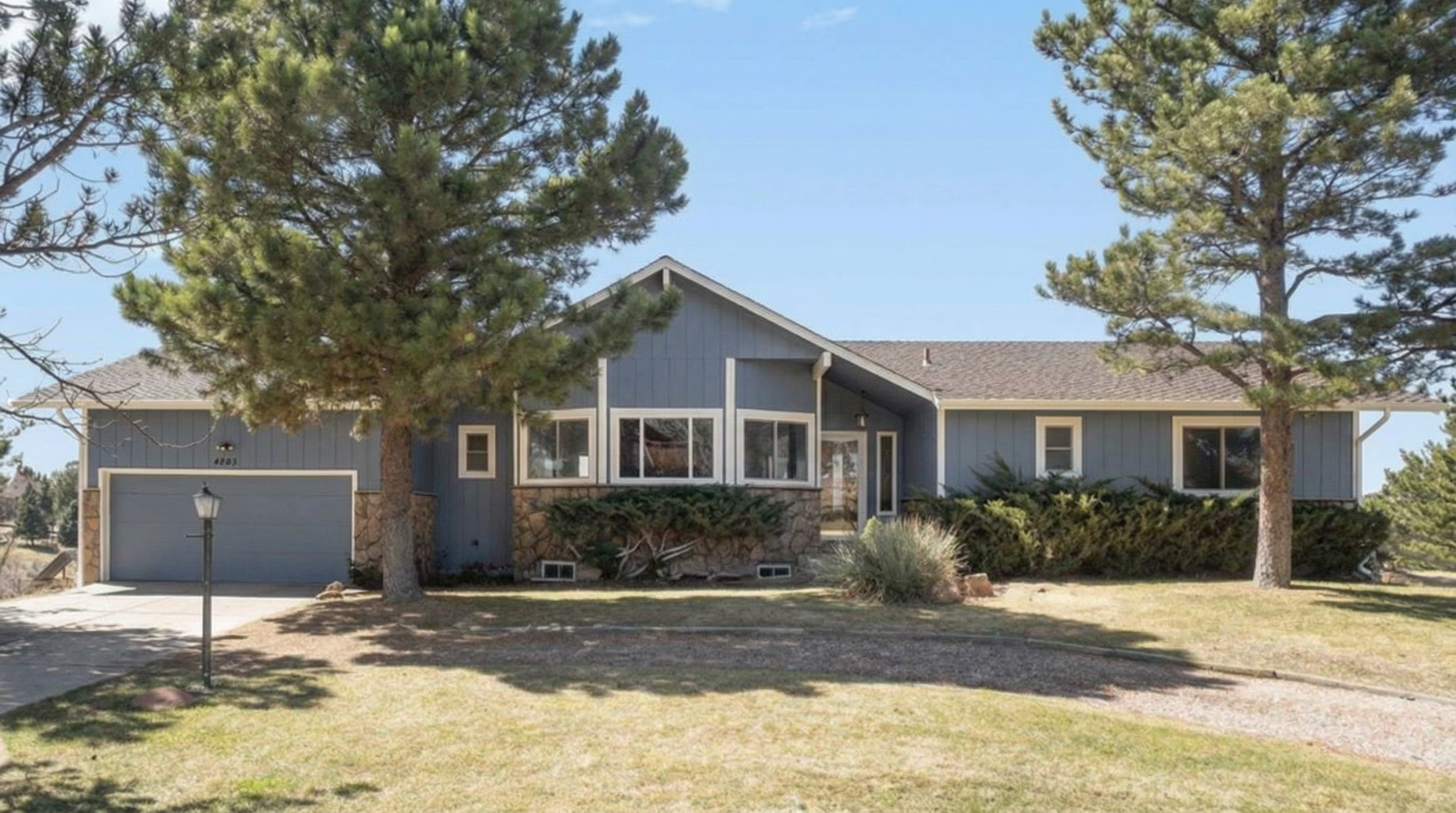 Modern home with blue exterior and stone accent wall
