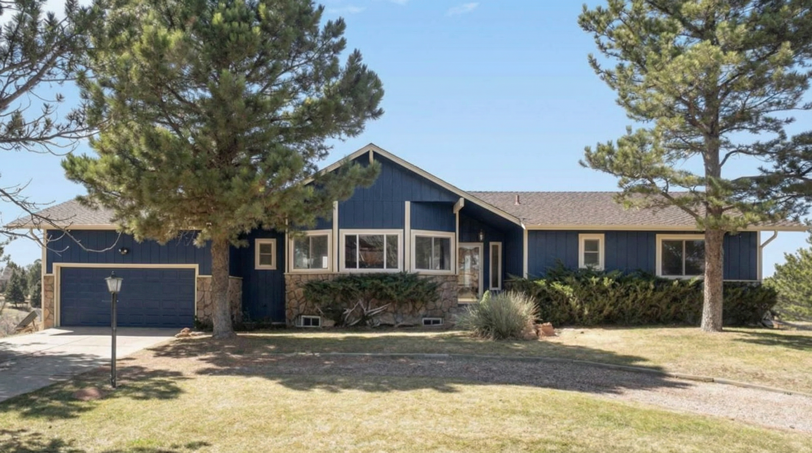 Blue ranch-style house with stone accents