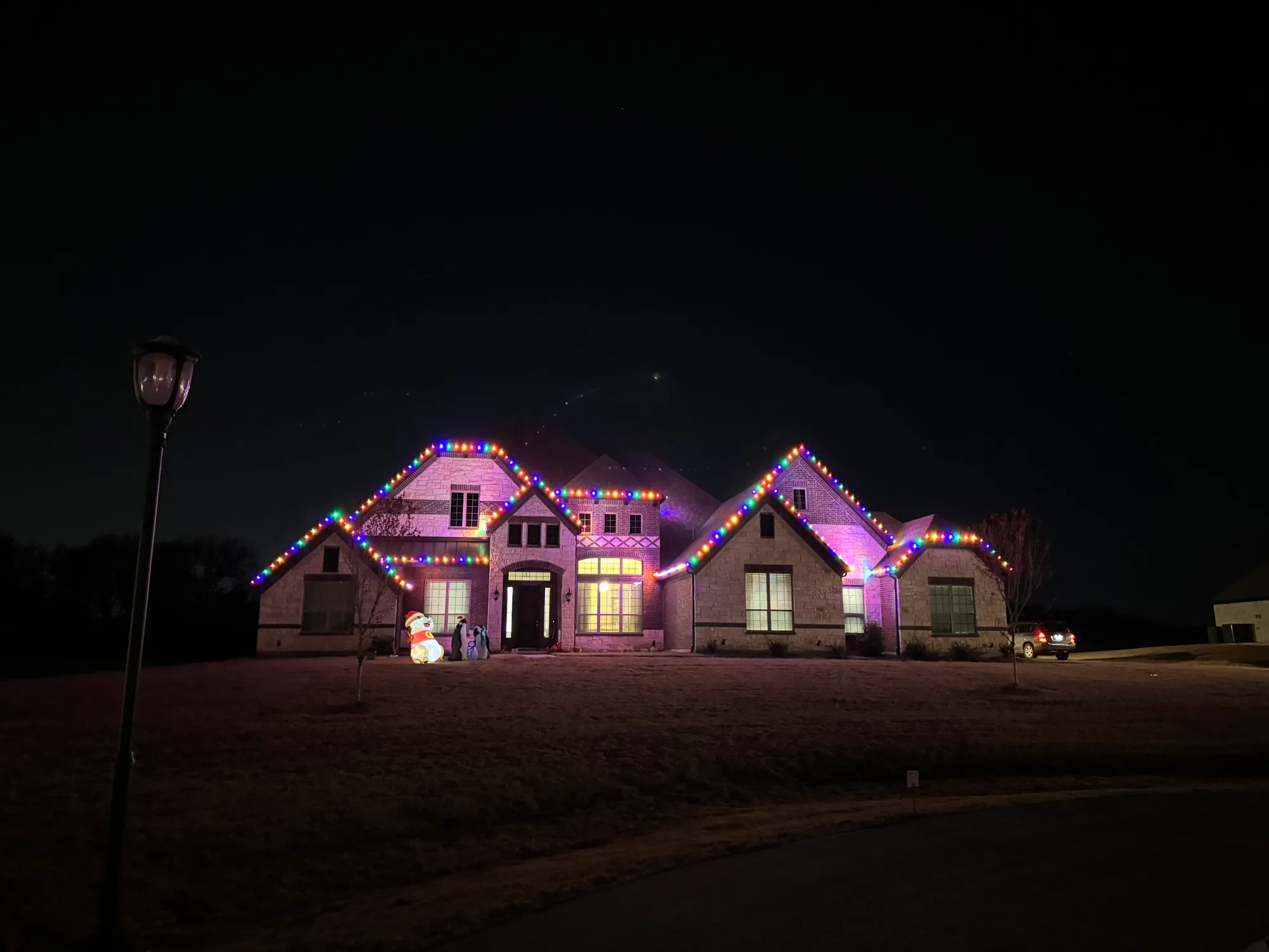 Large stone home with a multicolour LED roofline in red, green, blue and warm white, one of the colour options available.