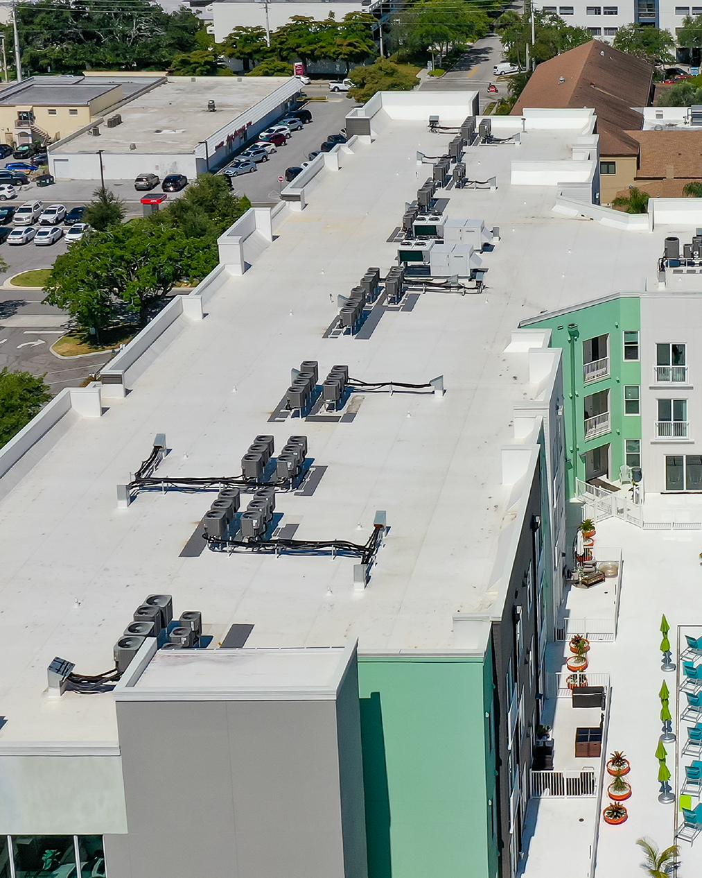 The Epoch tower seen from the air with the low-rise Sarasota skyline and treeline behind.
