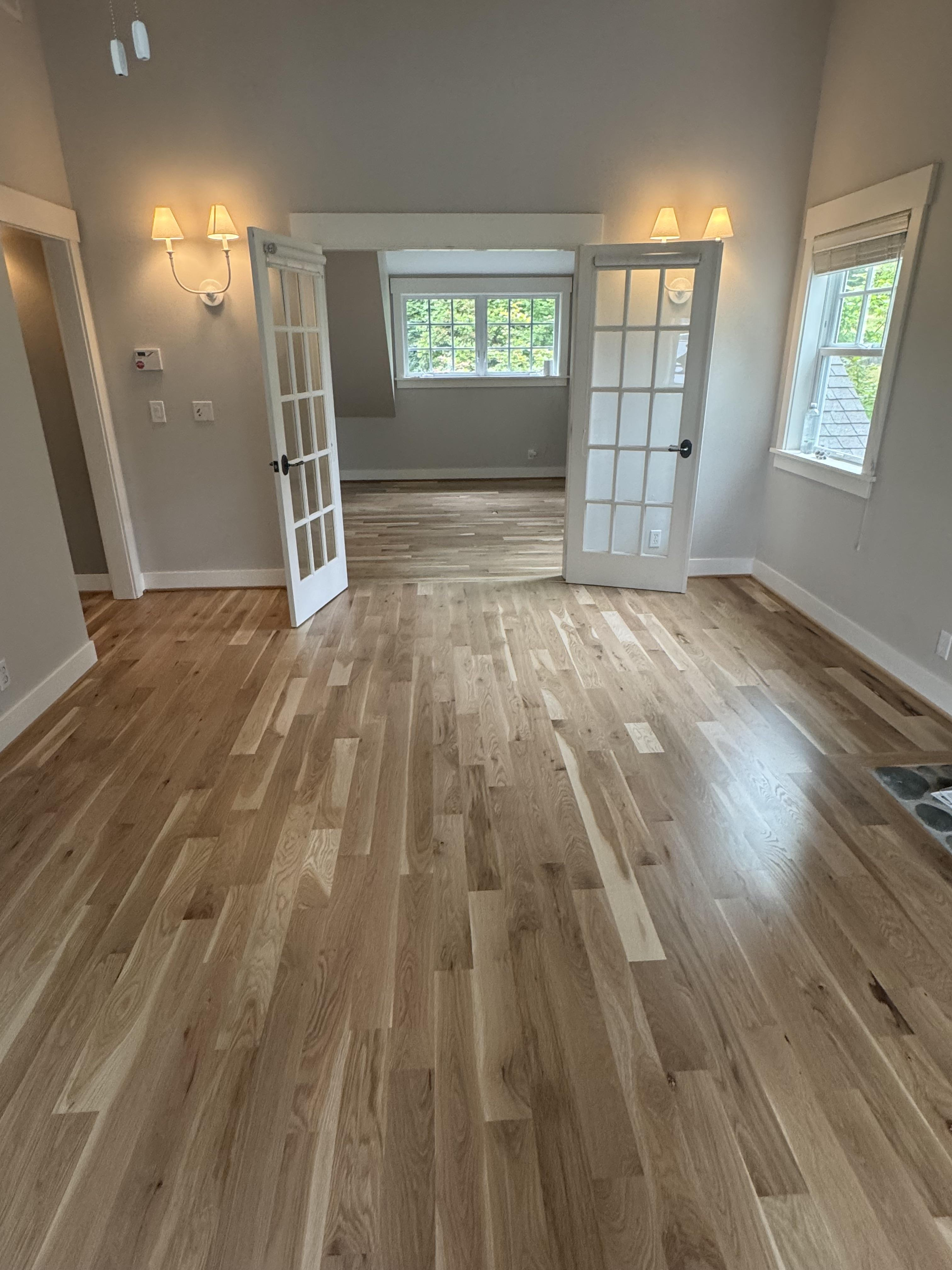 Bright living space with polished hardwood flooring and French glass doors
