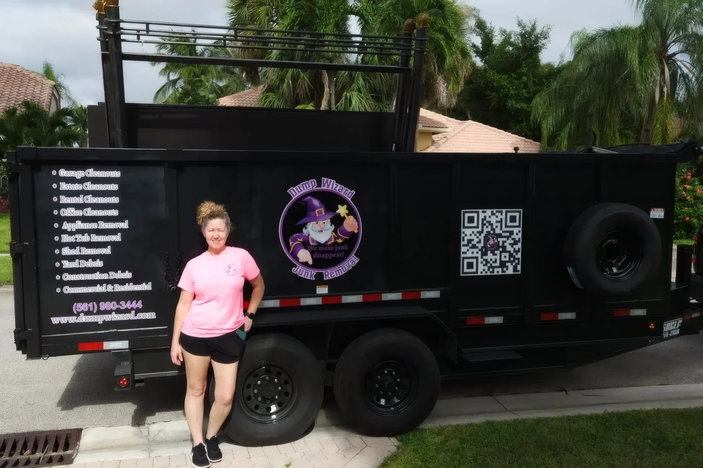 Walker family team member beside the fully wrapped Dump Wizard trailer