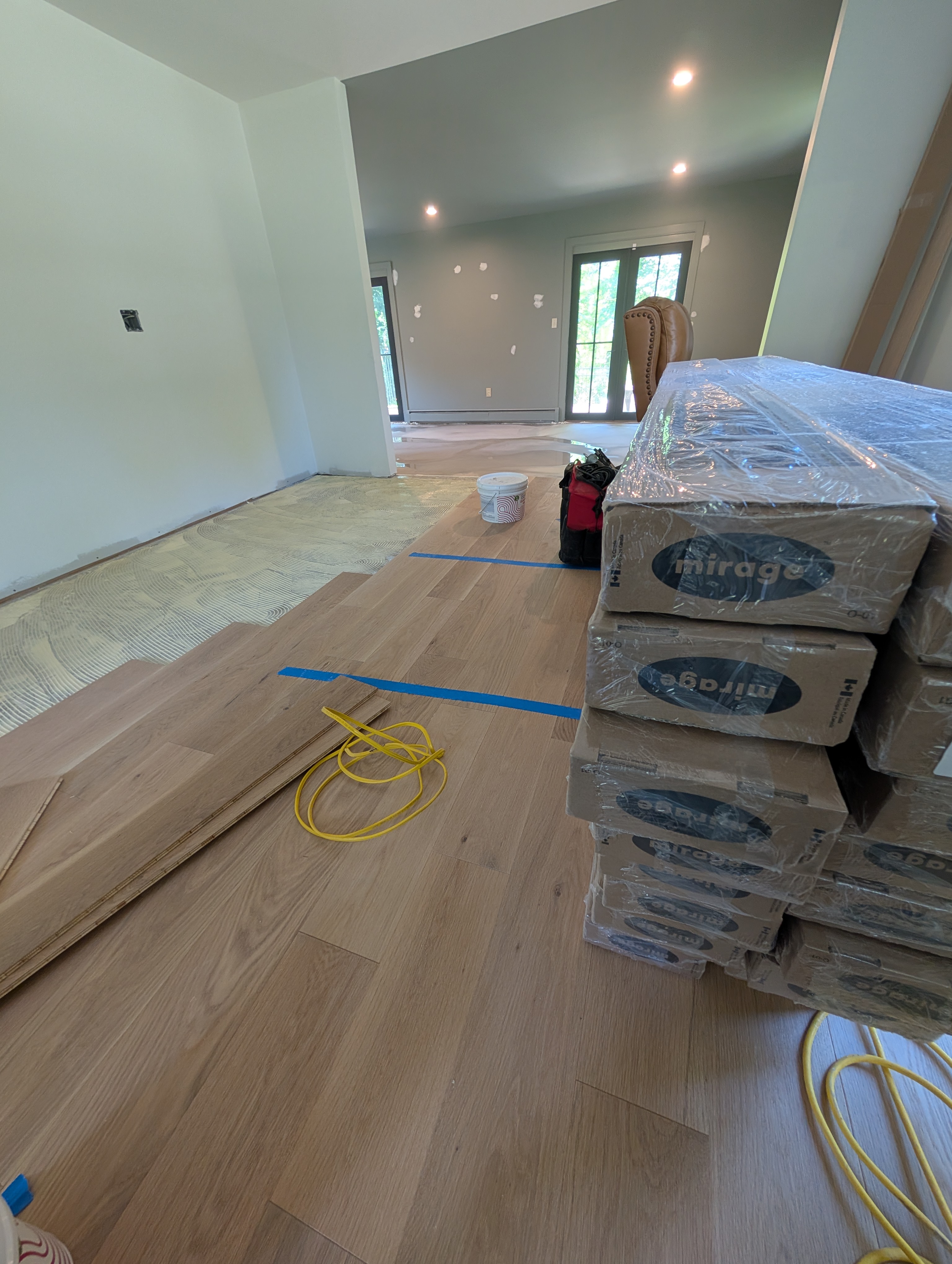 Interior renovation with newly laid wooden flooring and stacked flooring boxes