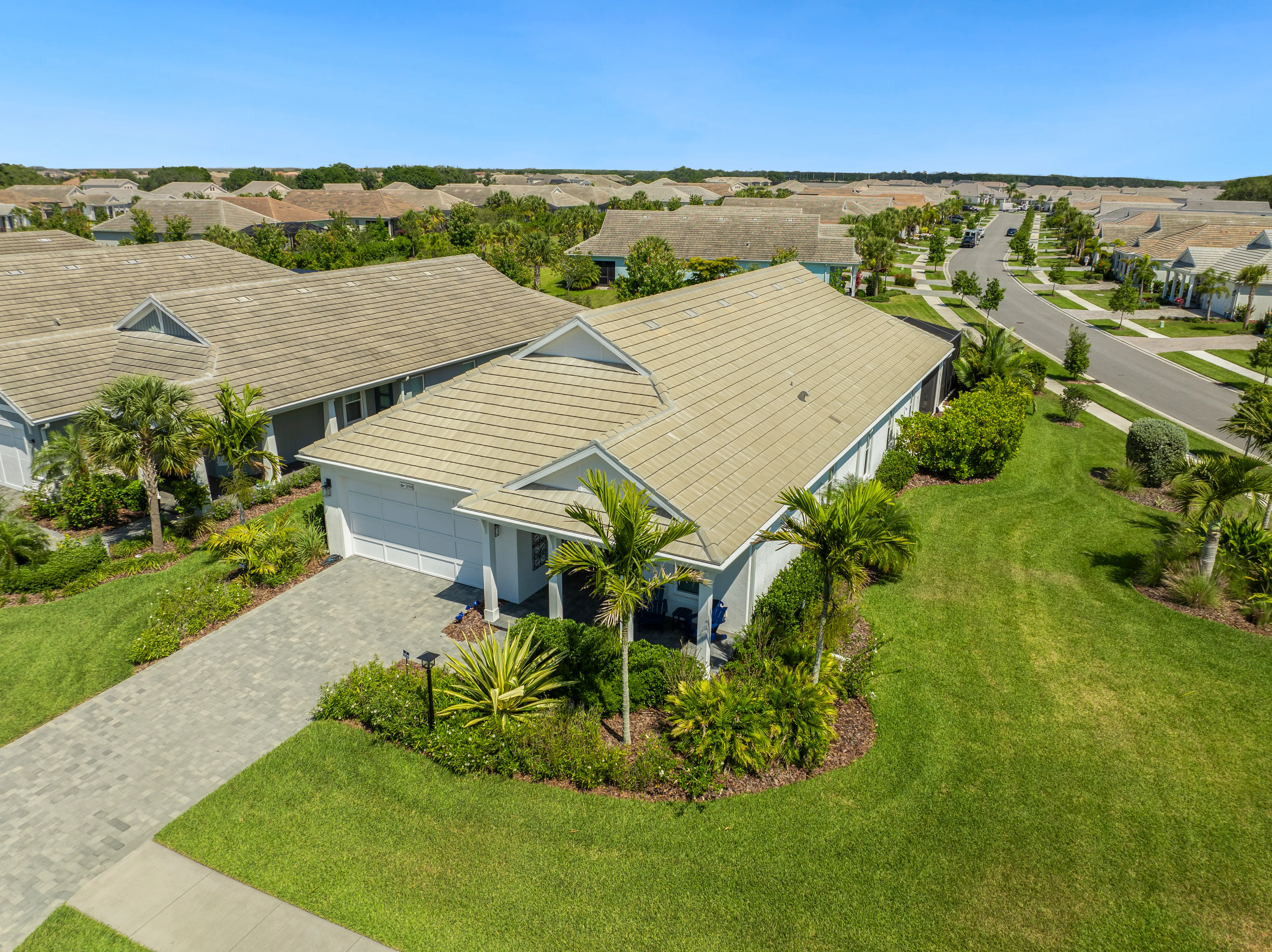 Aerial view of a modern single-story home with manicured landscaping in a Sarasota subdivision.