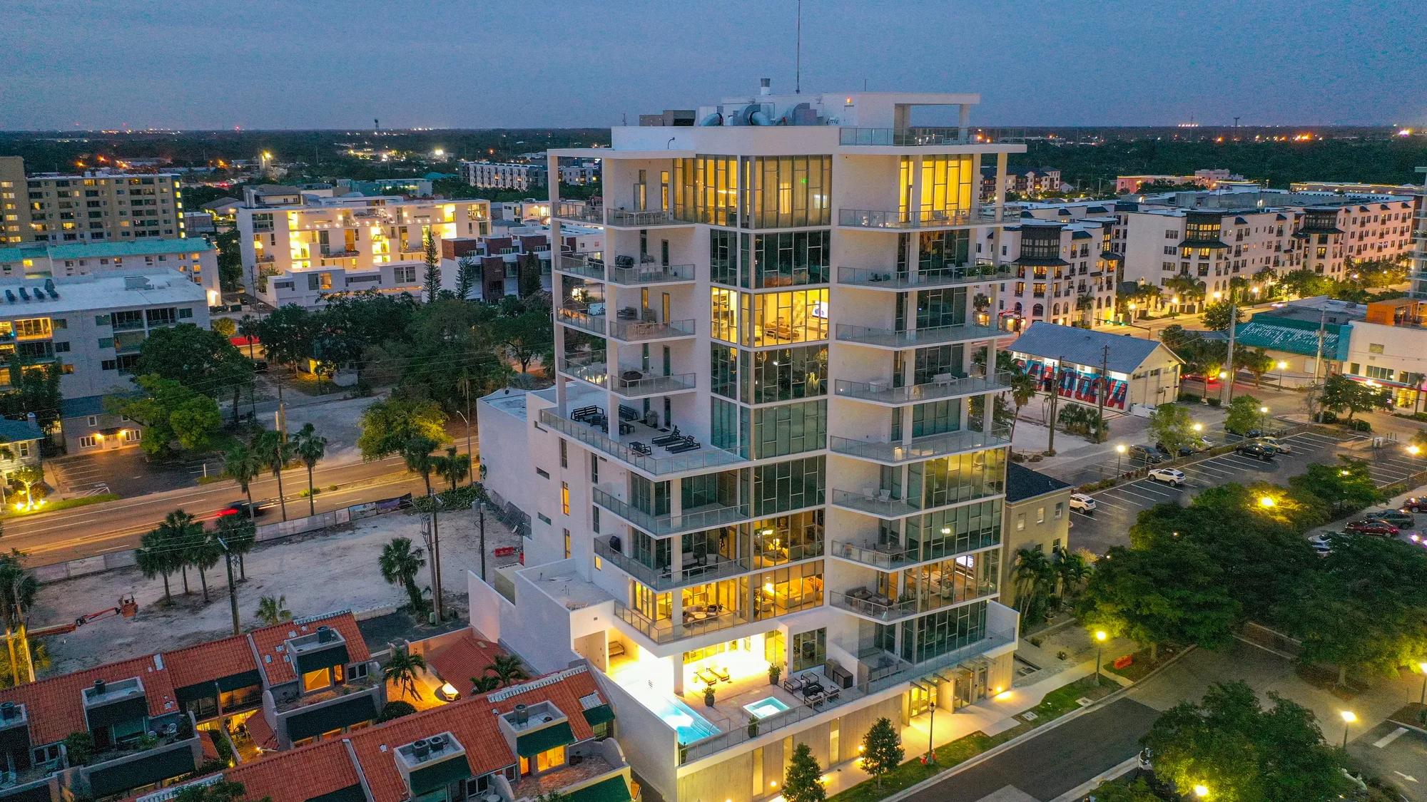 Aerial of The Epoch, a glass-and-white residential tower, against a clear blue sky.
