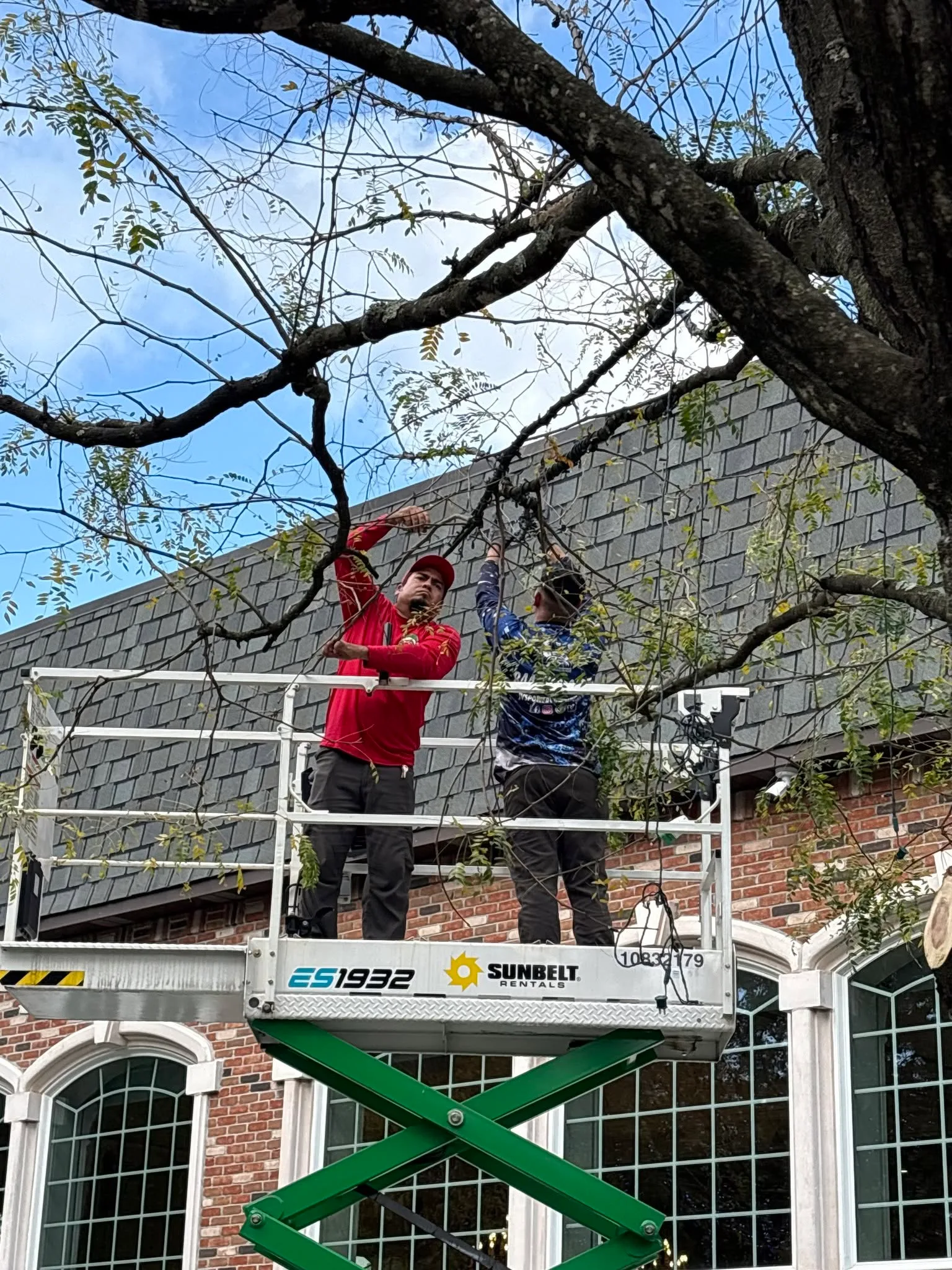 Crew installing holiday lights on a residential home