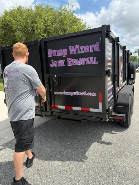 Crew member closing up the wrapped Dump Wizard trailer after a pickup