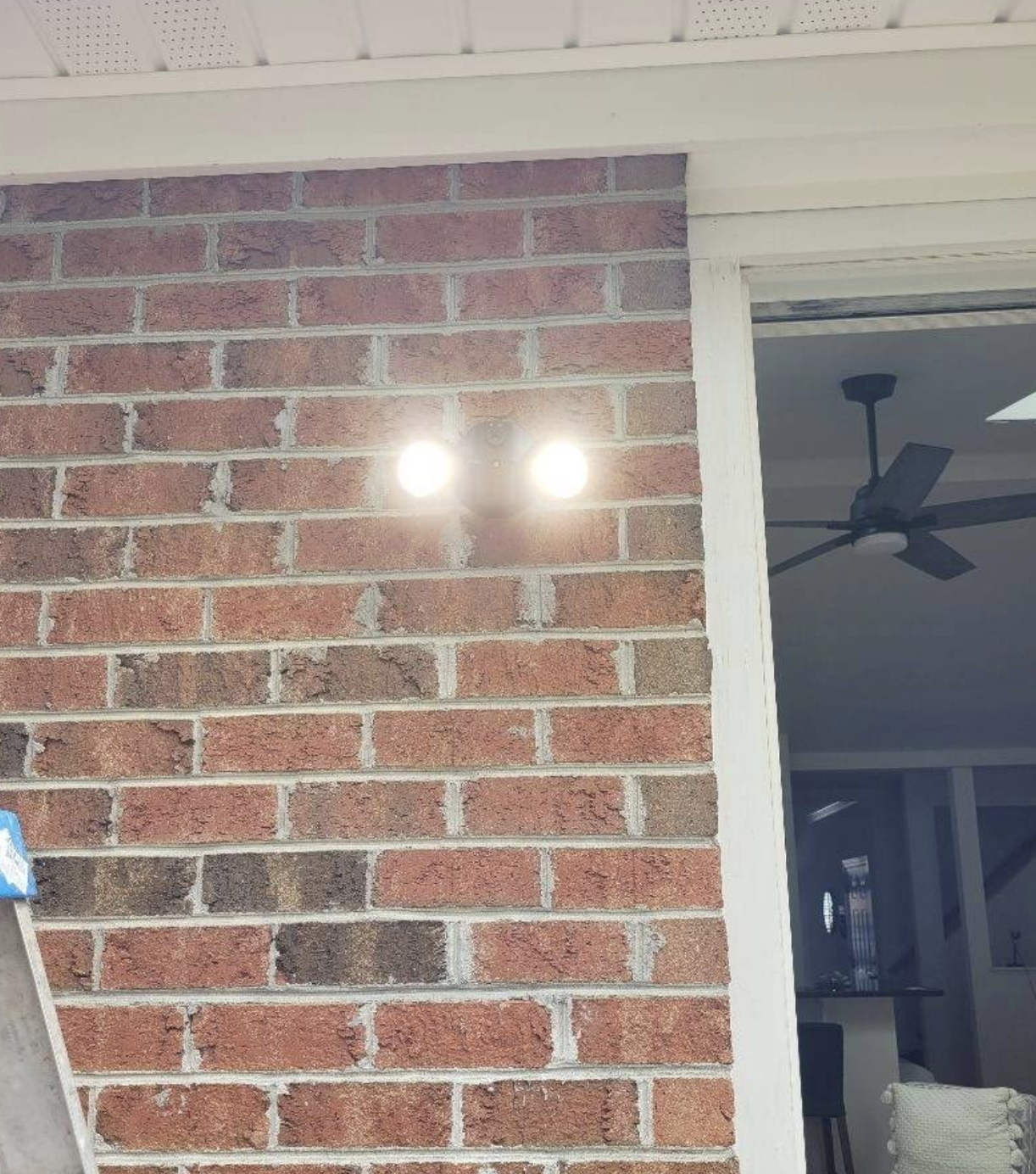 Newly installed outdoor wall light on a brick exterior