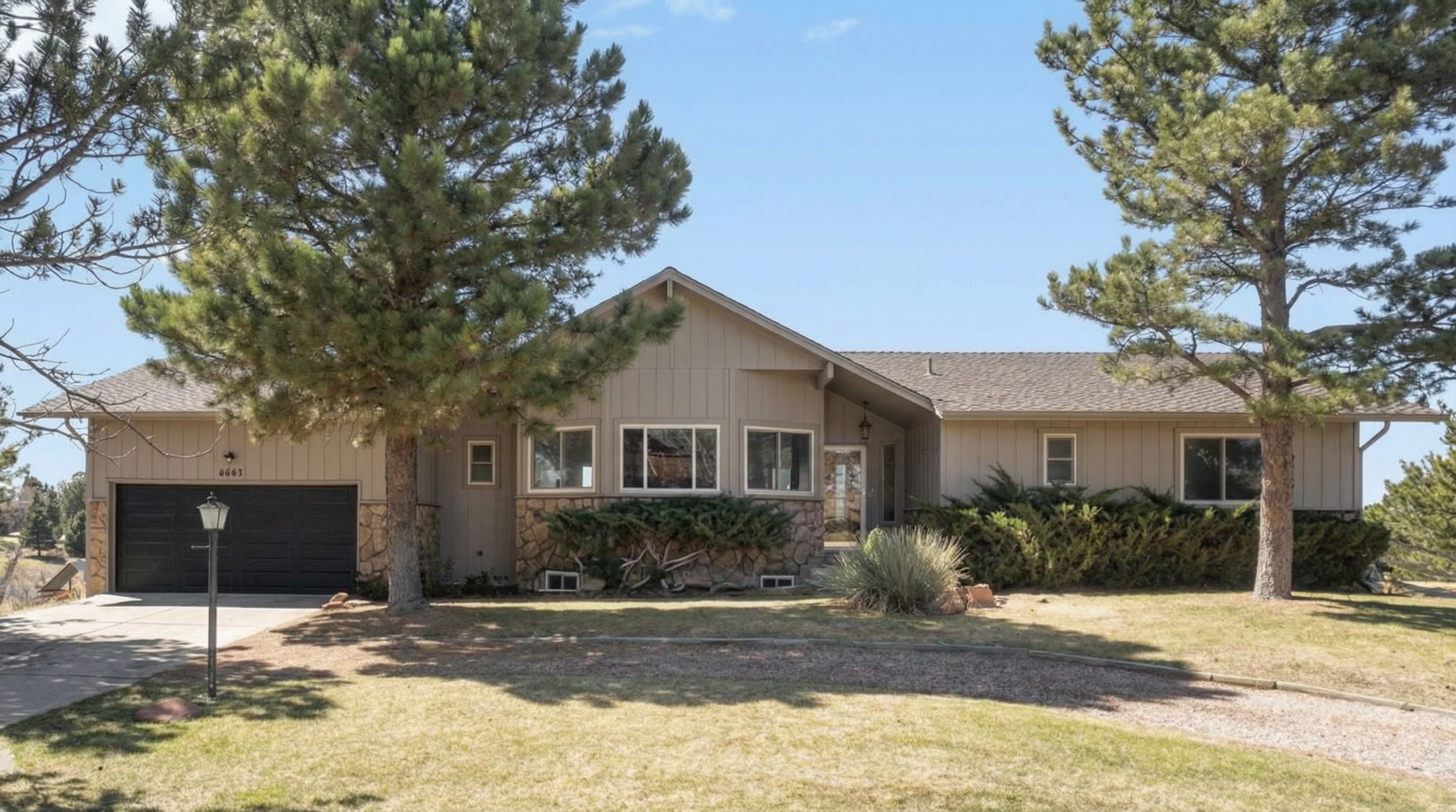 Residential house with driveway, garage, and landscaped front yard