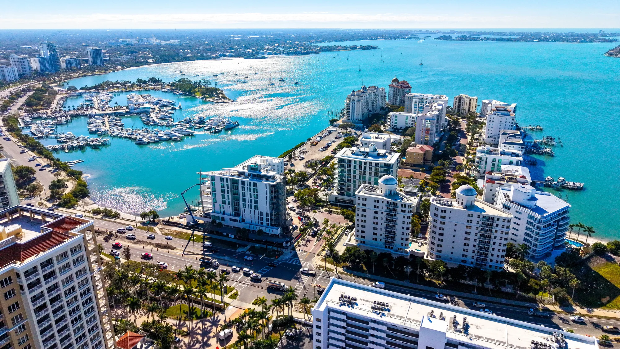 Aerial over Sarasota's bayfront showing the Six88 development, marina and turquoise water of the bay.