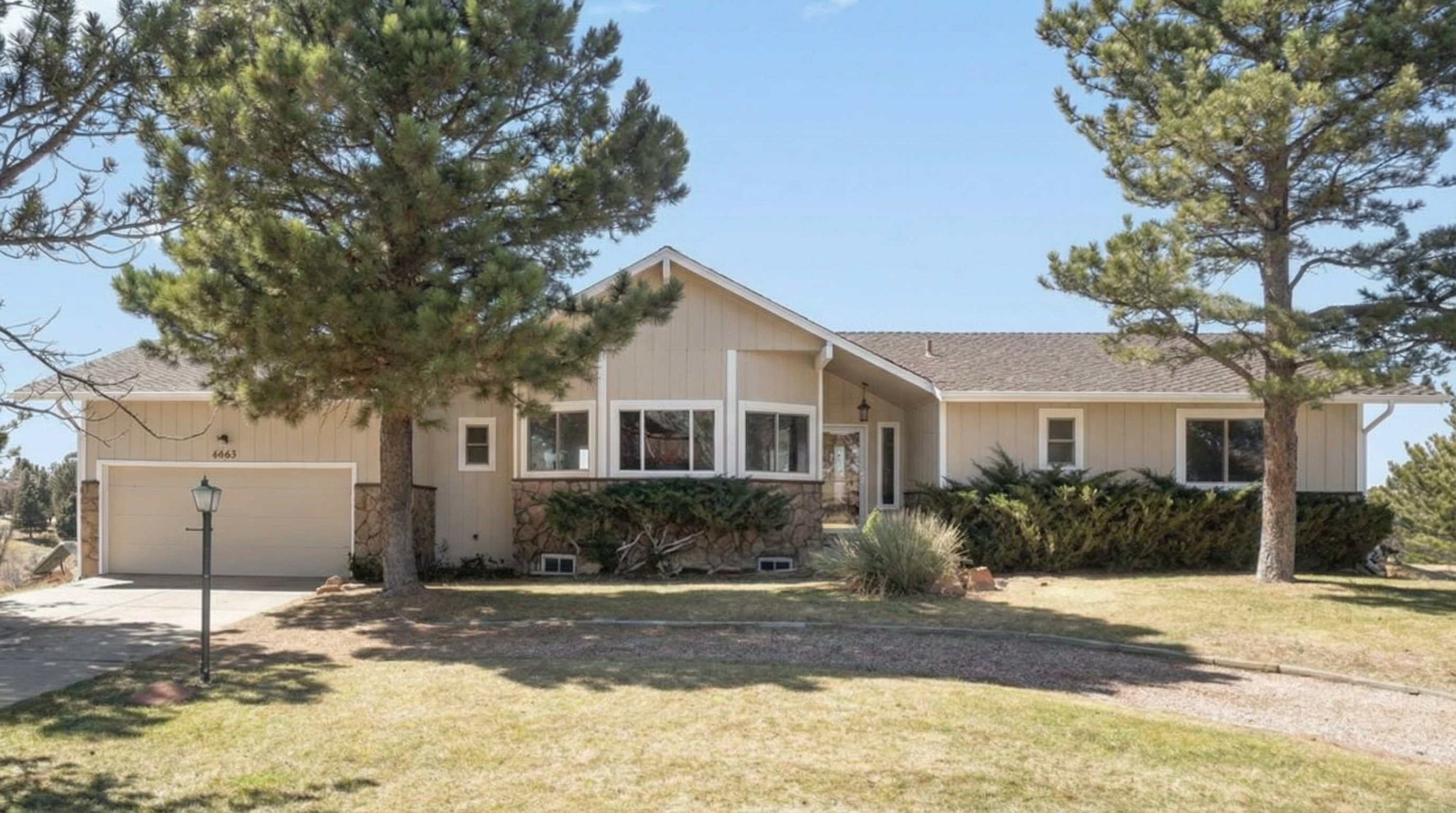 Family home with beige siding and stone-accented entryway