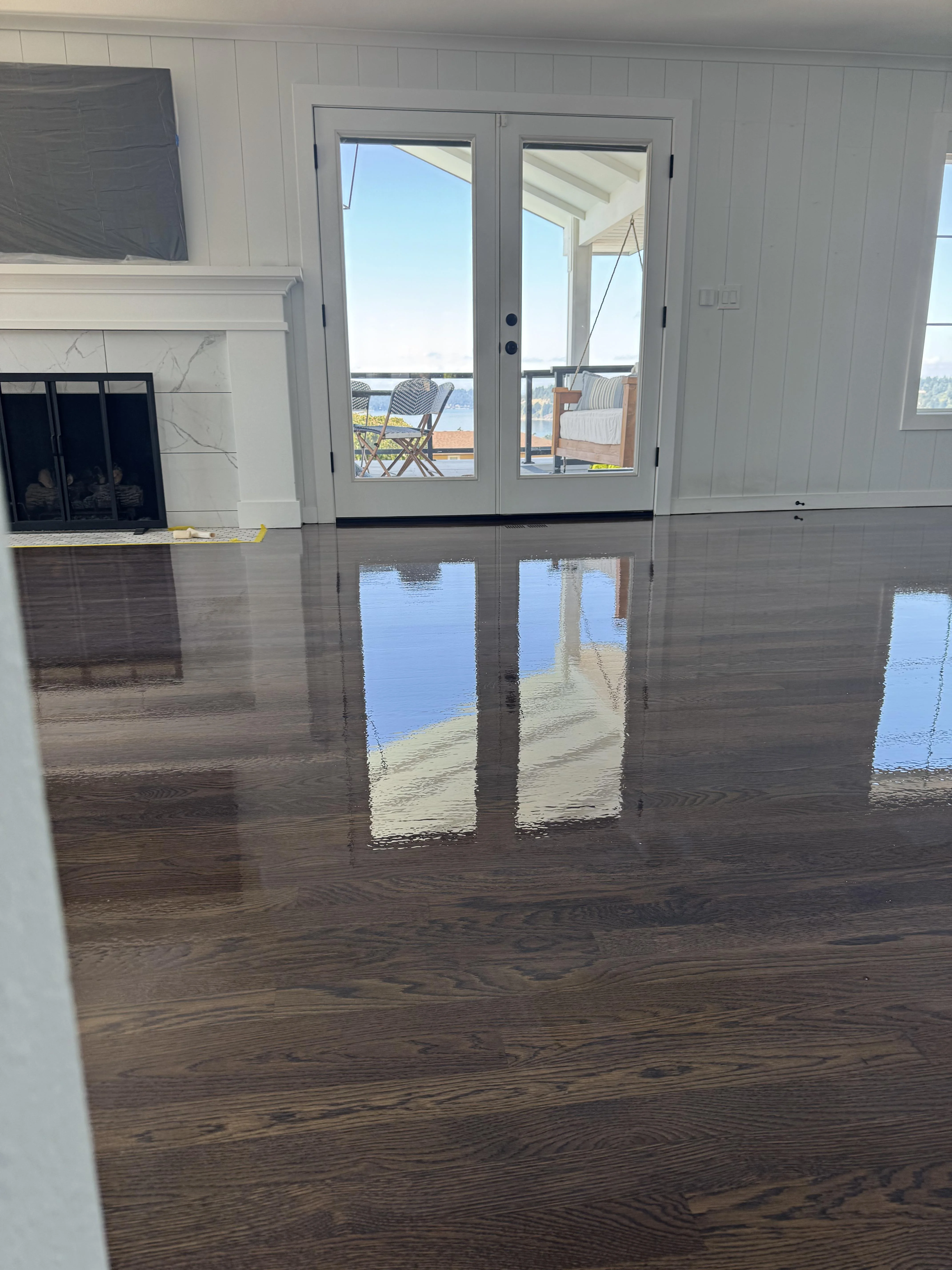 Living room with rich polished hardwood floors and large glass doors