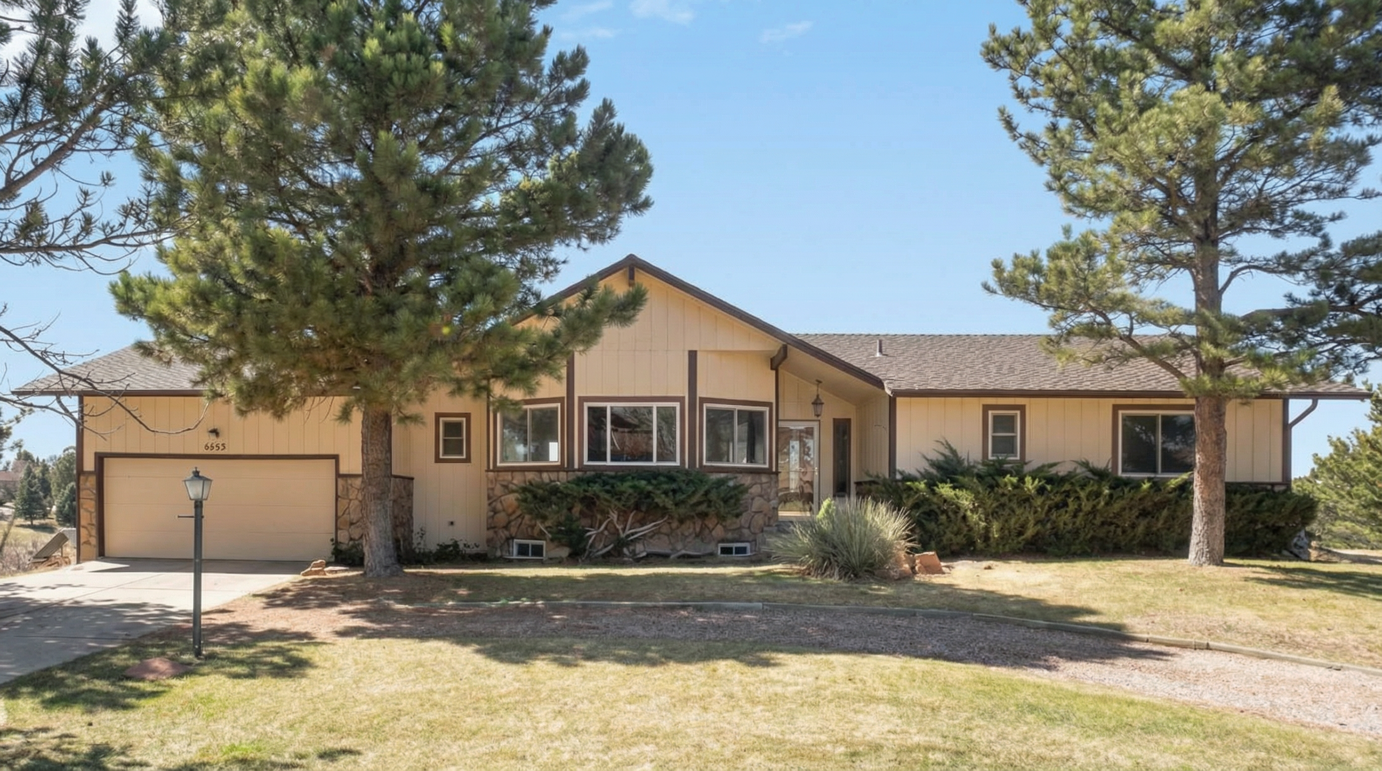 Single-story home with light-colored exterior and stone accents