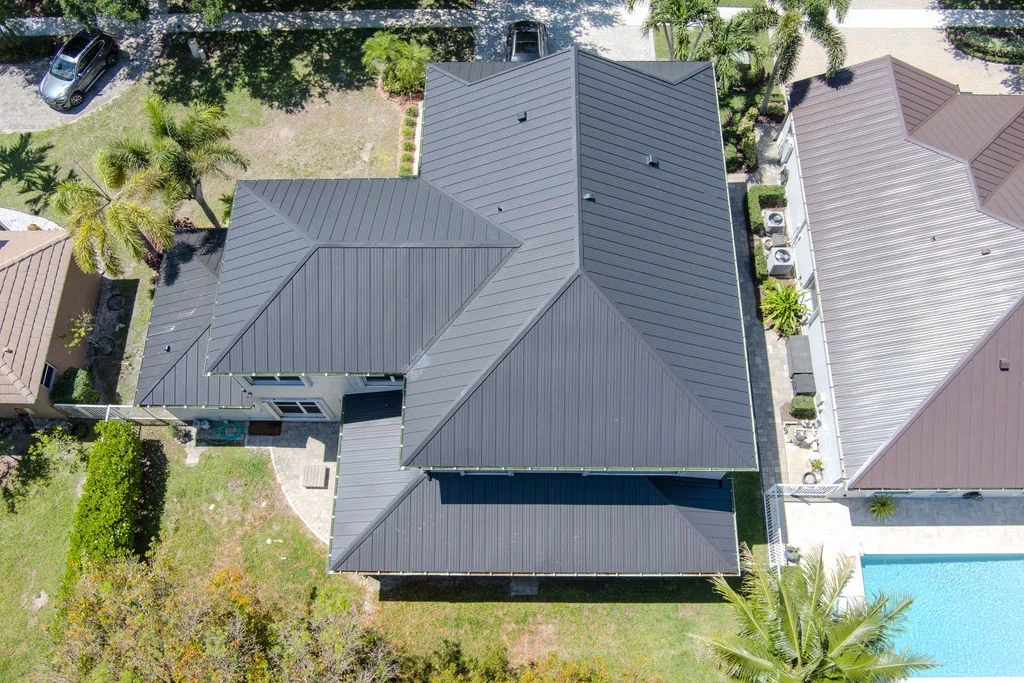 Aerial view of several residential buildings with dark metal roofing and landscaped lawns on the Treasure Coast
