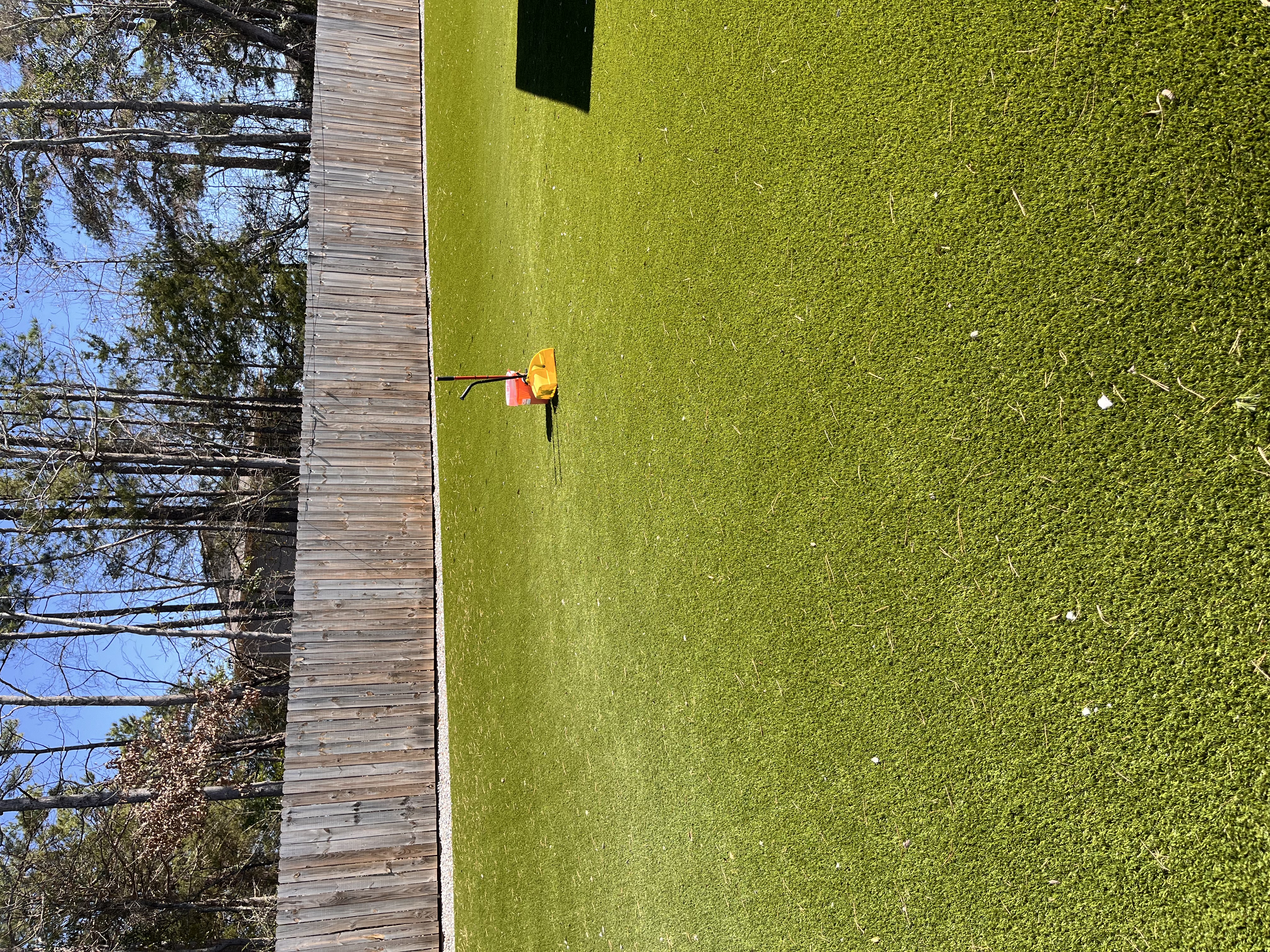 Clean artificial turf lawn with deodorizing tools ready for application