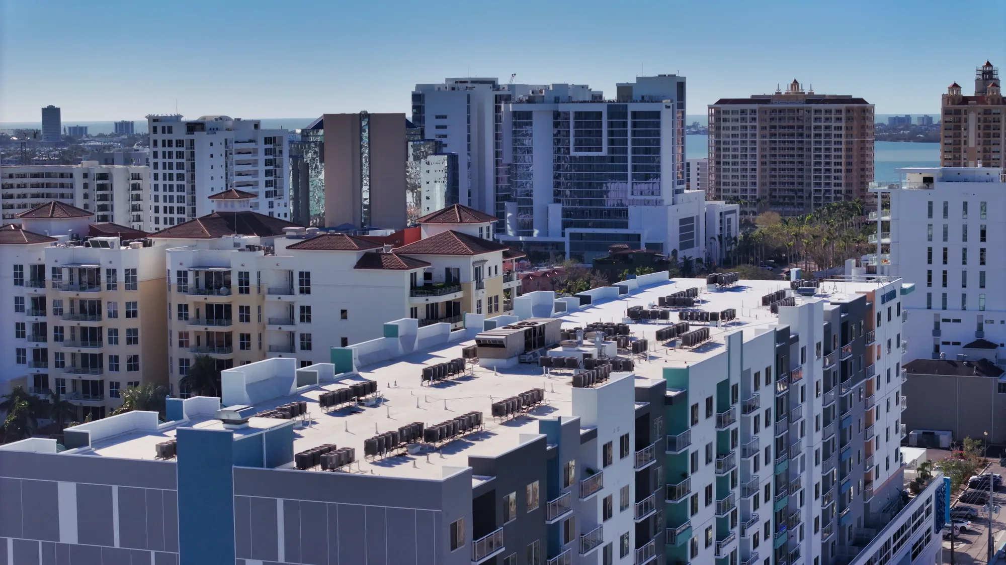 Aerial over Sarasota's bayfront showing the Six88 development, marina and turquoise water of the bay.