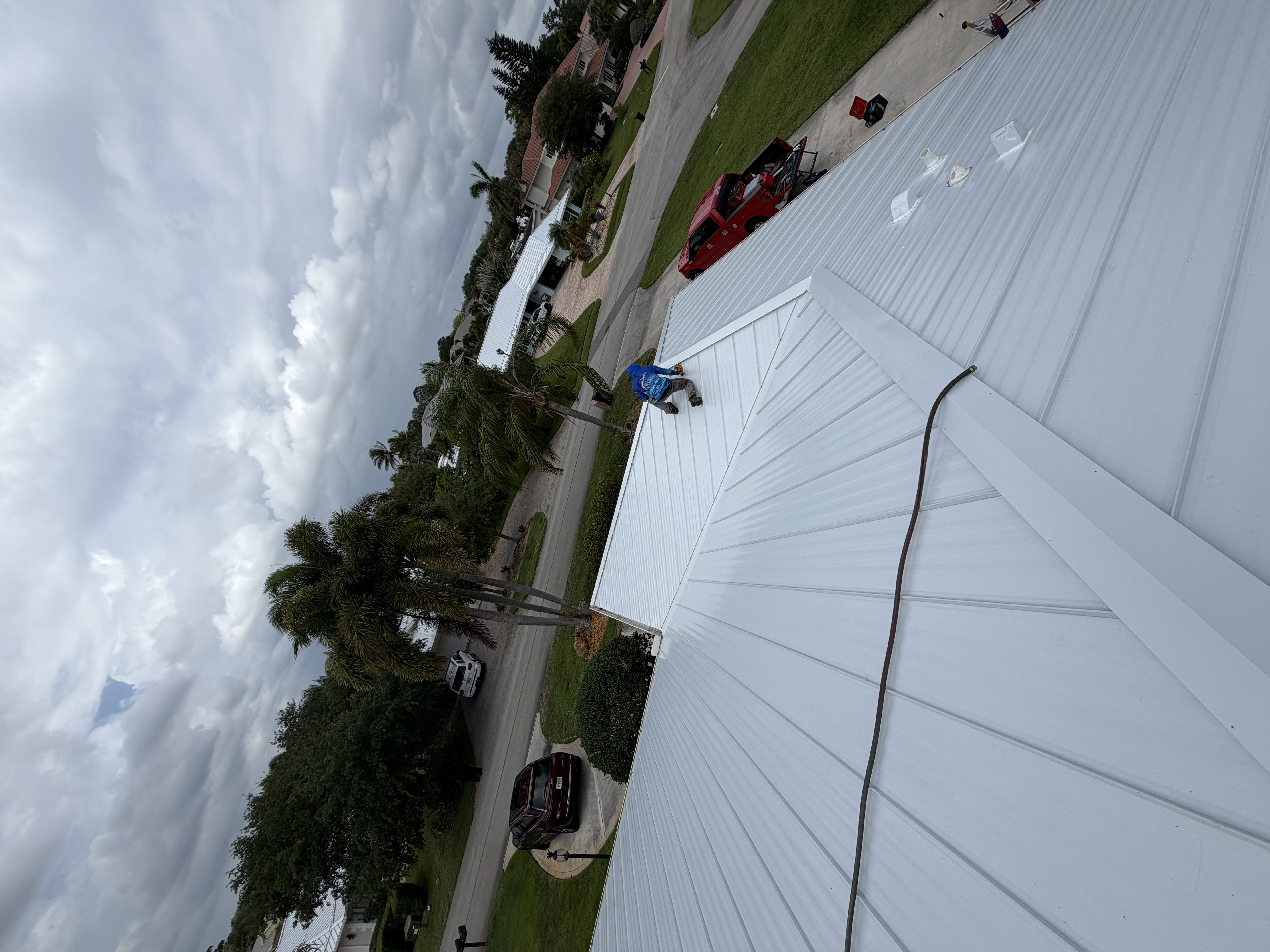 Roofing professional performing preventative maintenance on a metal roof on the Treasure Coast