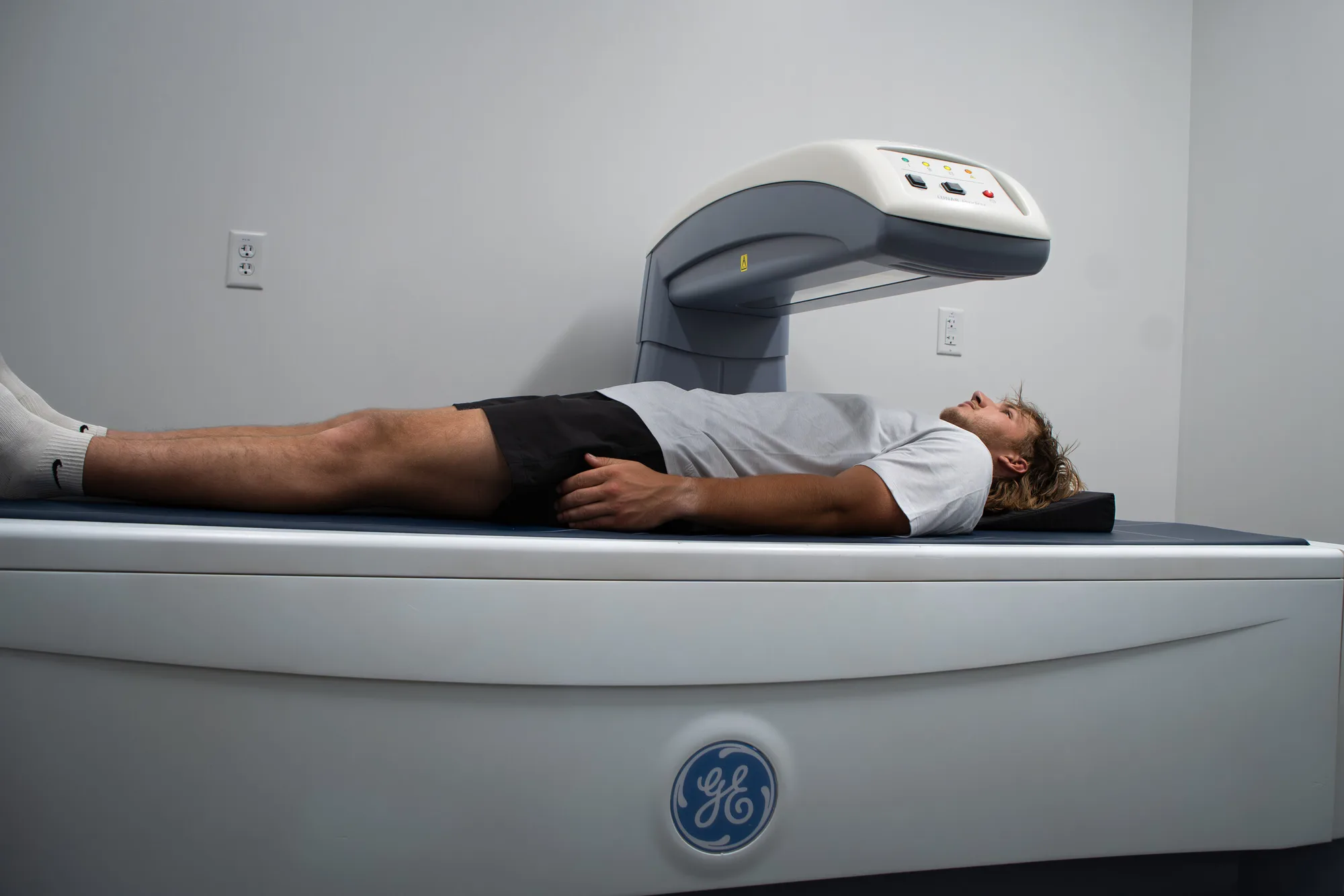 A patient undergoing a DEXA body-composition scan on a GE Lunar scanner at Forge Health & Performance.